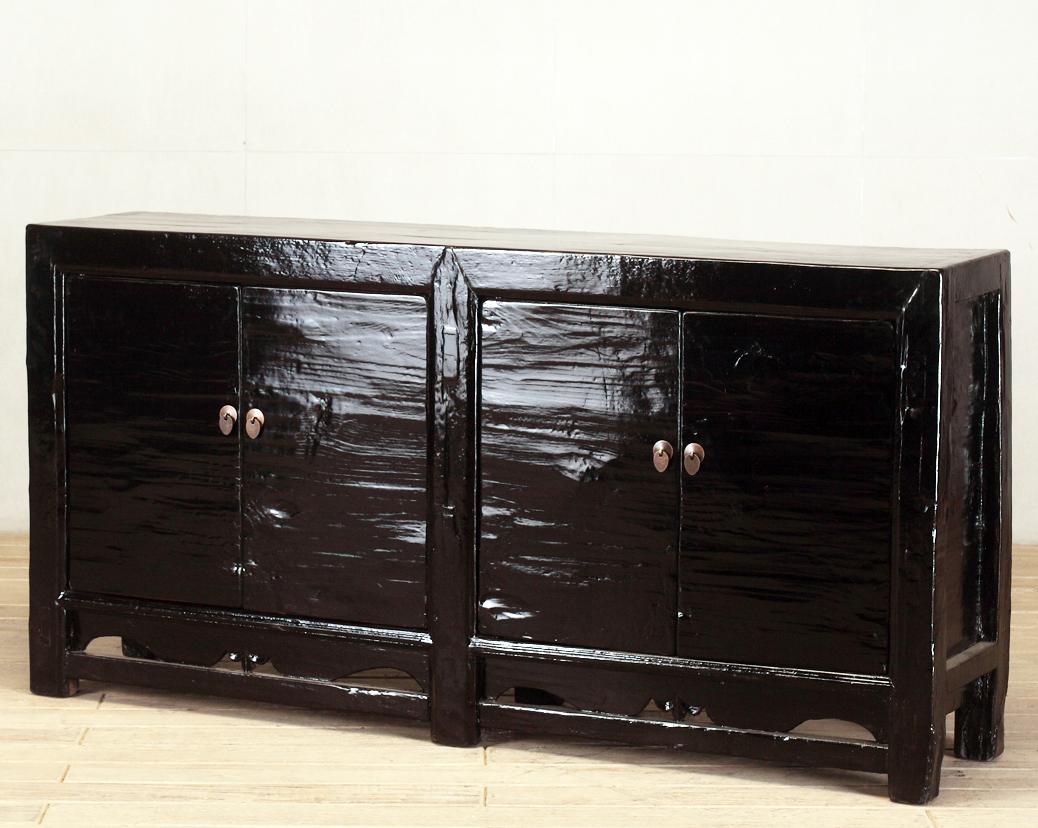 This red-lacquered Chinese sideboard was made from reclaimed pine wood with traditional nail-less joinery. The black lacquer has been enhanced with a sophisticated French polish finish. The piece was restored in a workshop using reclaimed wood in