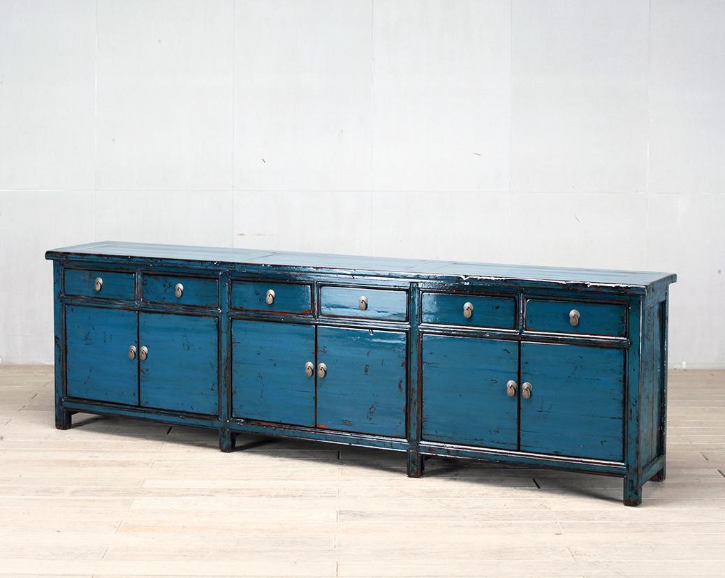 This sideboard was made from reclaimed elmwood with traditional nail-less joinery. The blue color on the piece has been enhanced with a sophisticated French polish finish. The piece was restored in a workshop using reclaimed wood in China and