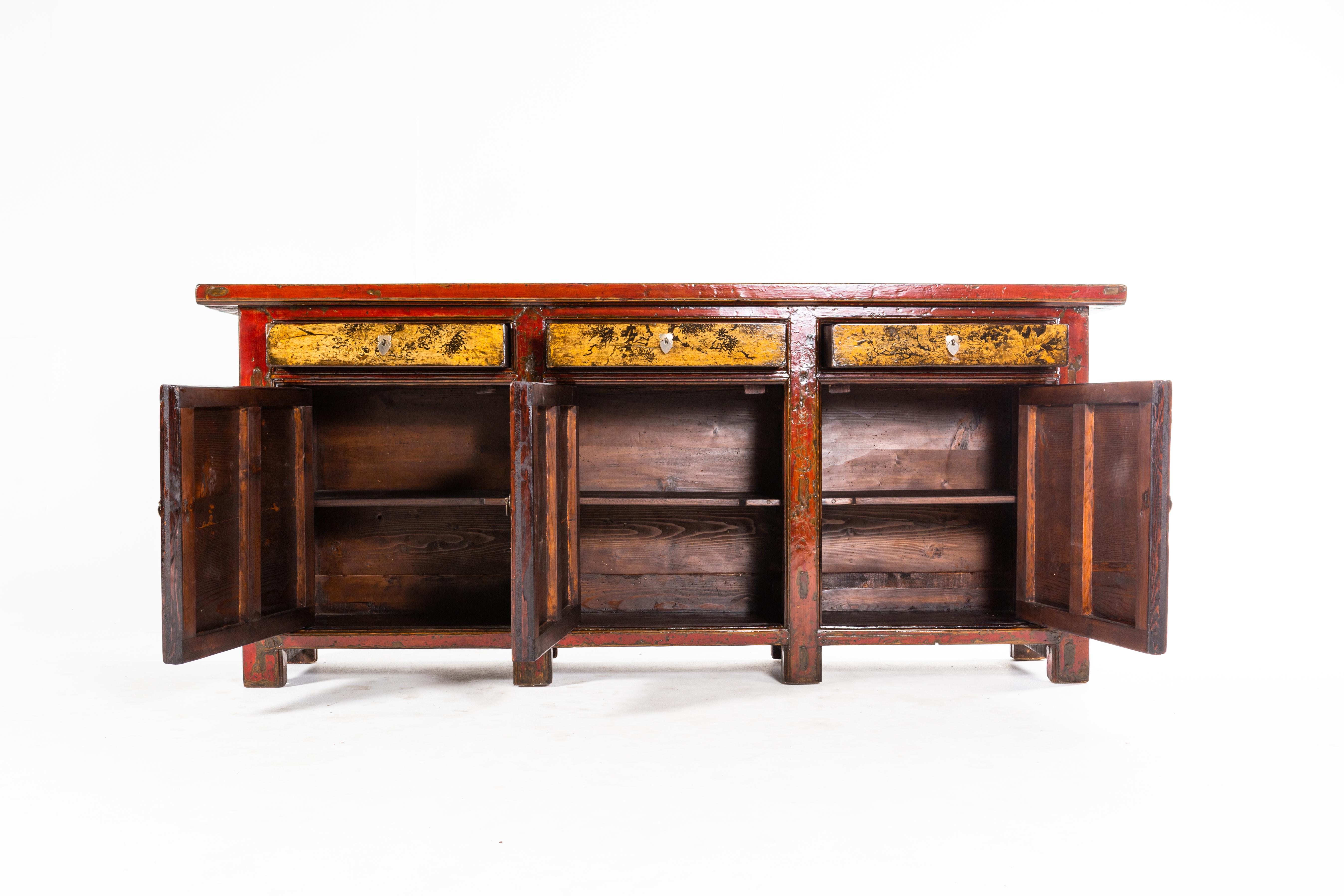 This gorgeous sideboard is from Gunsu, China and was made from pine wood, elmwood, and paint, circa 1920. The piece features a beautifully aged patina, 3 drawers, 3 doors, and shelves. Wear consistent with age and use.