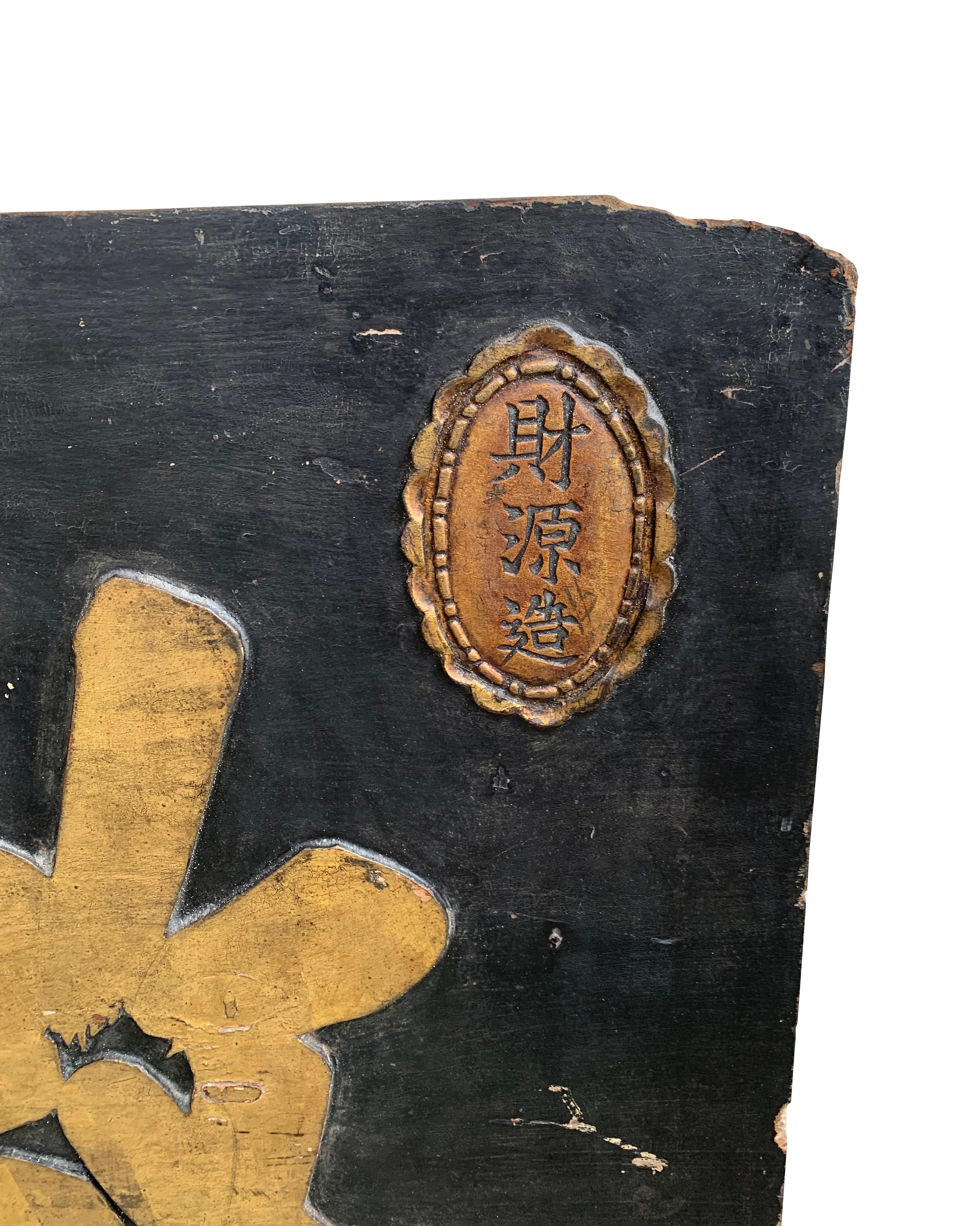 Mit einem holzfarbenen Sockel hebt dieses Schild (das komplett aus Holz gefertigt ist) 3 große goldfarbene chinesische Schriftzeichen hervor. Das Schild stammt aus dem frühen 20. Jahrhundert und ist durch die Alterung des Holzes und das Verblassen