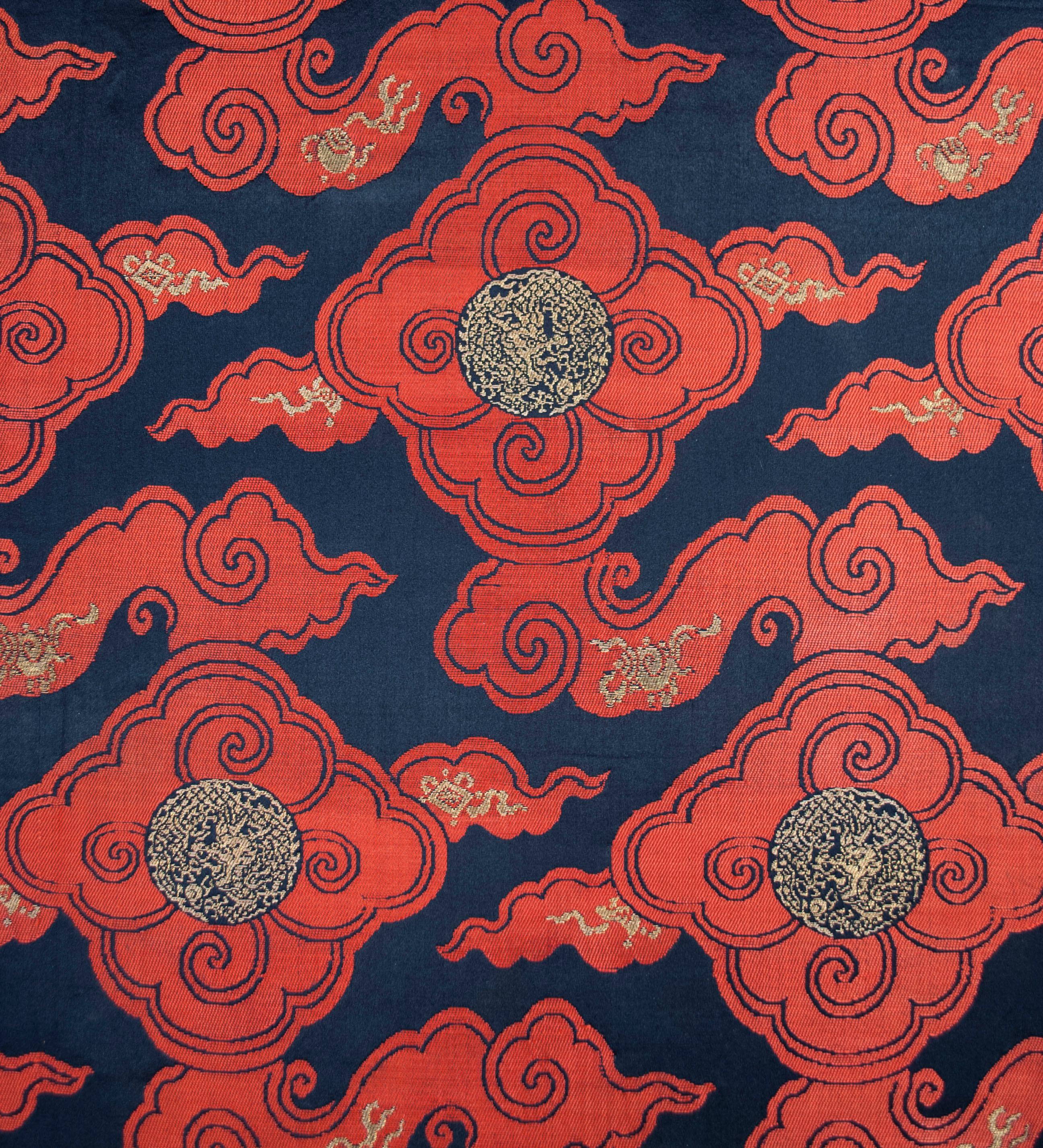 Chinese silk cloud-band textile with dragon roundels, circa 1800-1825.

A graphically compelling Qing period silk with a pattern of red cloud-bands (silk twill weave) floating across a dark blue field (silk satin), with roundels of facing dragons