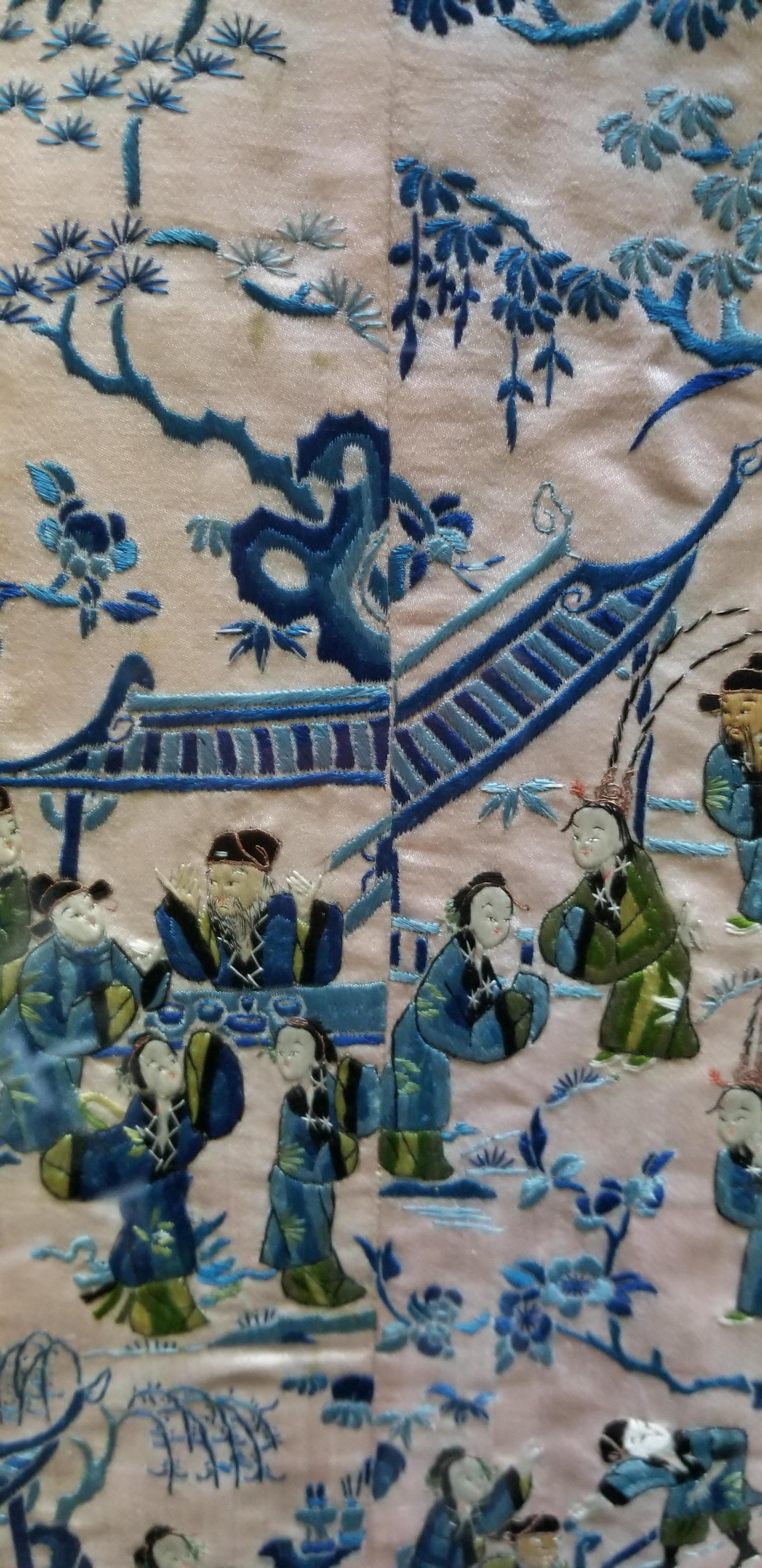 Antique hand embroidered Chinese silk robe sleeve bands professionally framed under plexiglass in a black lacquer wood frame. Depicting male and female figures, pagoda, flora and trees. Primary colors cobalt blue, light blue, green, beige and black.