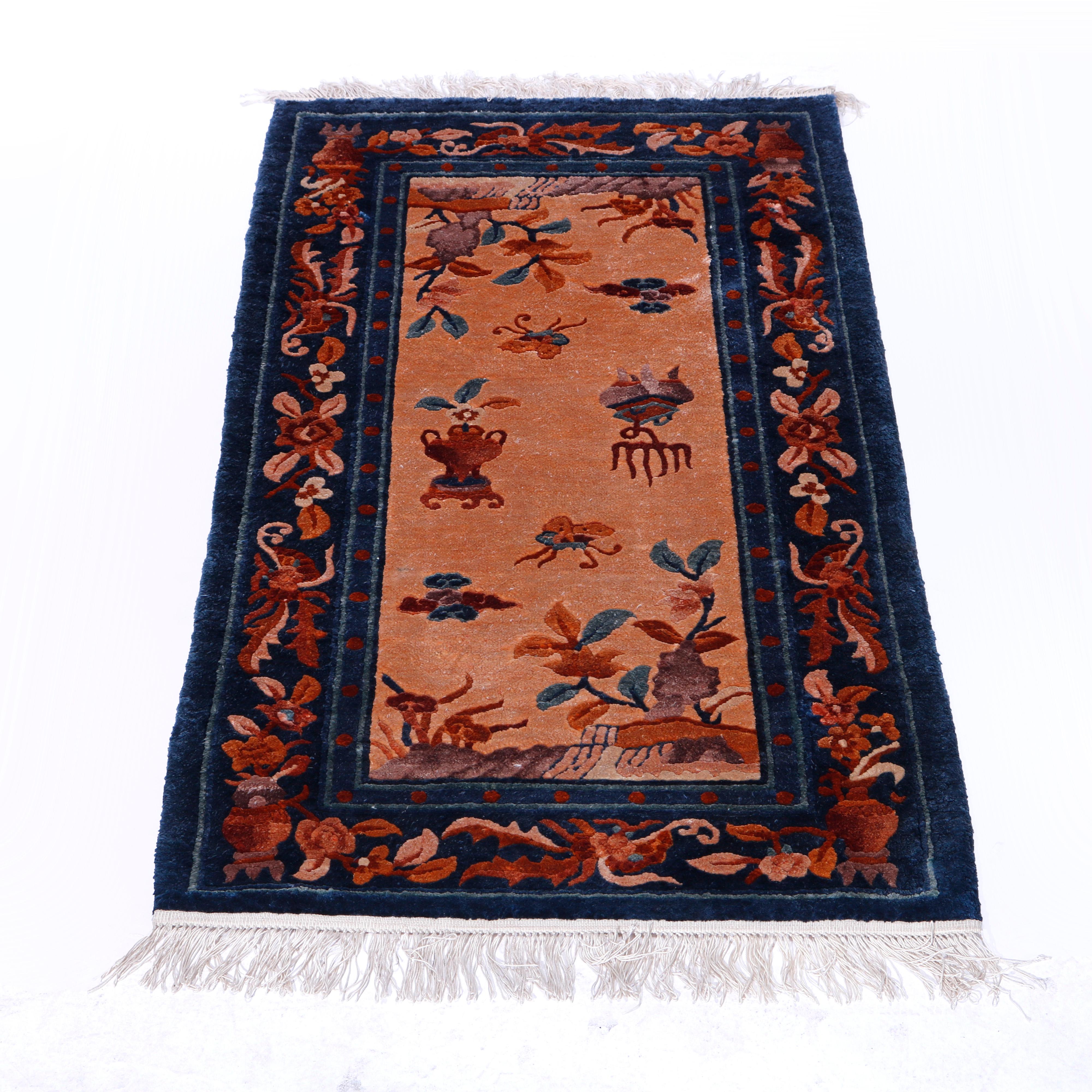 A Chinese oriental rug offers silk construction with ground having garden scene with flowers, butterflies and urns, complementing border having foliate design, 20th century

Measures - 50''W x 24.75''D x .5''H.