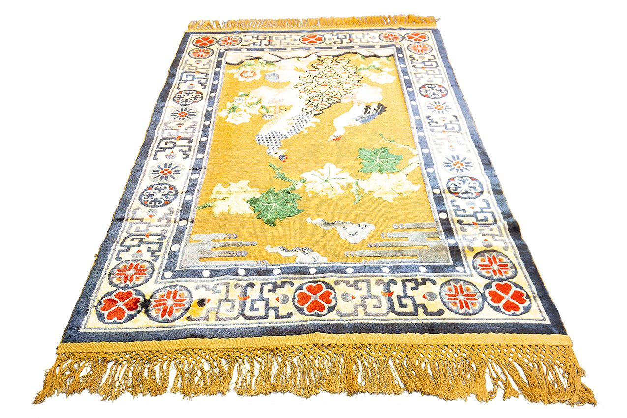 This magnificent Chinese carpet knotted in the last century with silk and metal thread on a cotton warp and weft measuring 176x123 cm, is designed with the dual possibility of being laid on the ground or hung like a tapestry. The background of the