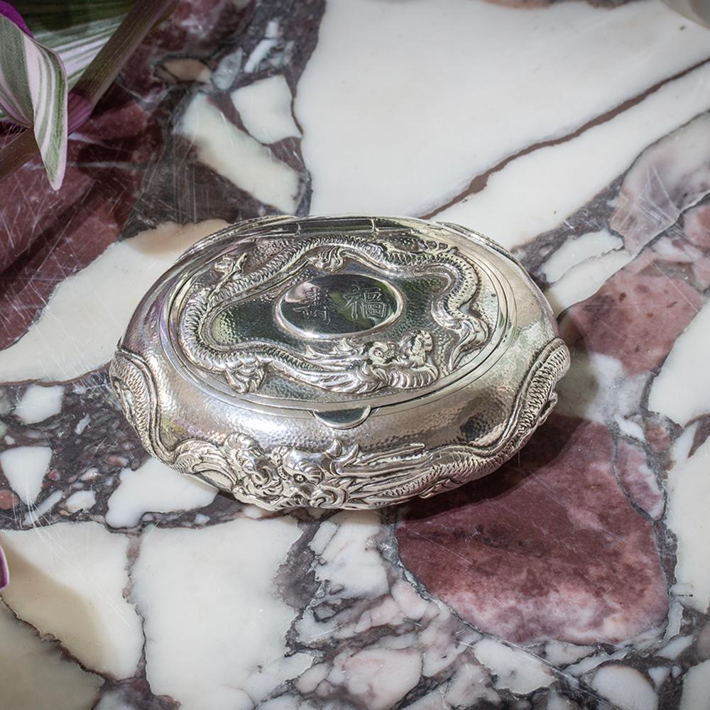 Circa 1910

From our Chinese collection, we are pleased to offer this Chinese Silver Dragon Snuff Box. The snuff box of oval form having a hammered decoration to the exterior with a large dragon all the way around the exterior of the body. The top