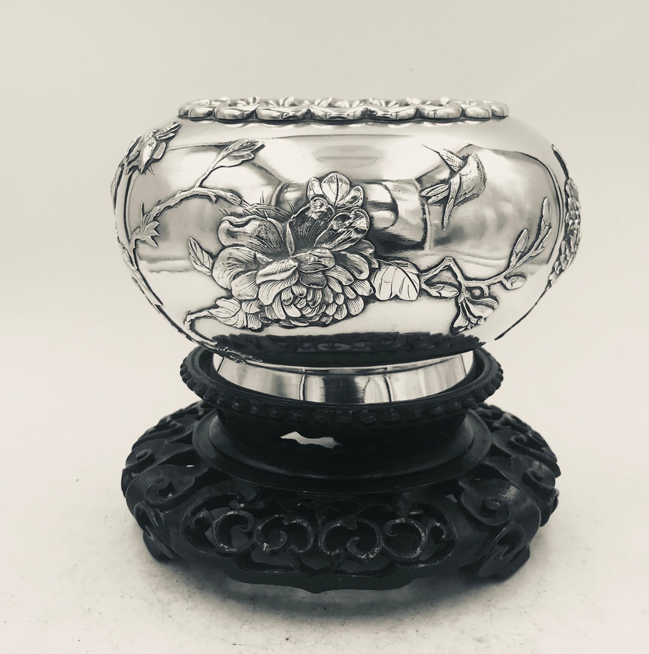 Chinese export silver bowl with applied chrysanthemum, prunus and birds. The bowl has a wavy rim, collet foot and gilt interior and is shown sitting on a pierced wood stand. Marked with '泰安‘ (TaiAn), which is a rare maker's mark, and retailer's mark