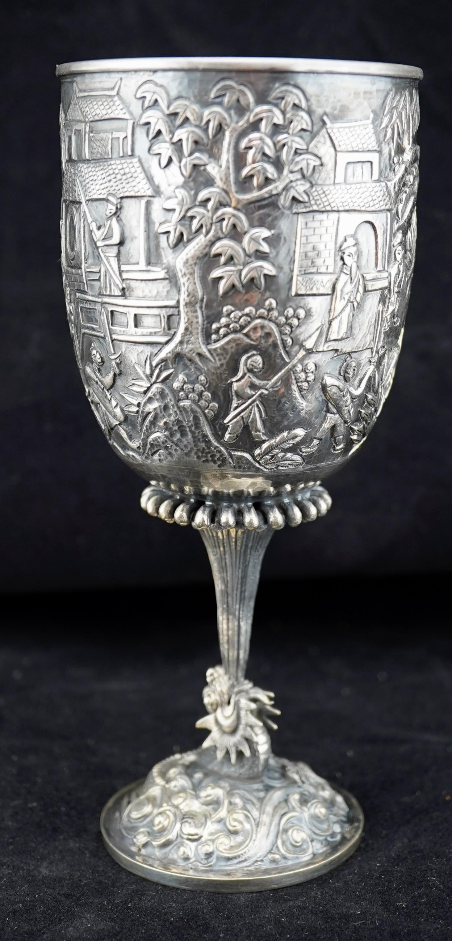Chinese silver repousse goblet by Wang Hing. Depicts Chinese garden scenes. Drgon base with emanating fire. Marked WH for Wang HIng maker and 90 Chinese silver. Weight 7.4 oz