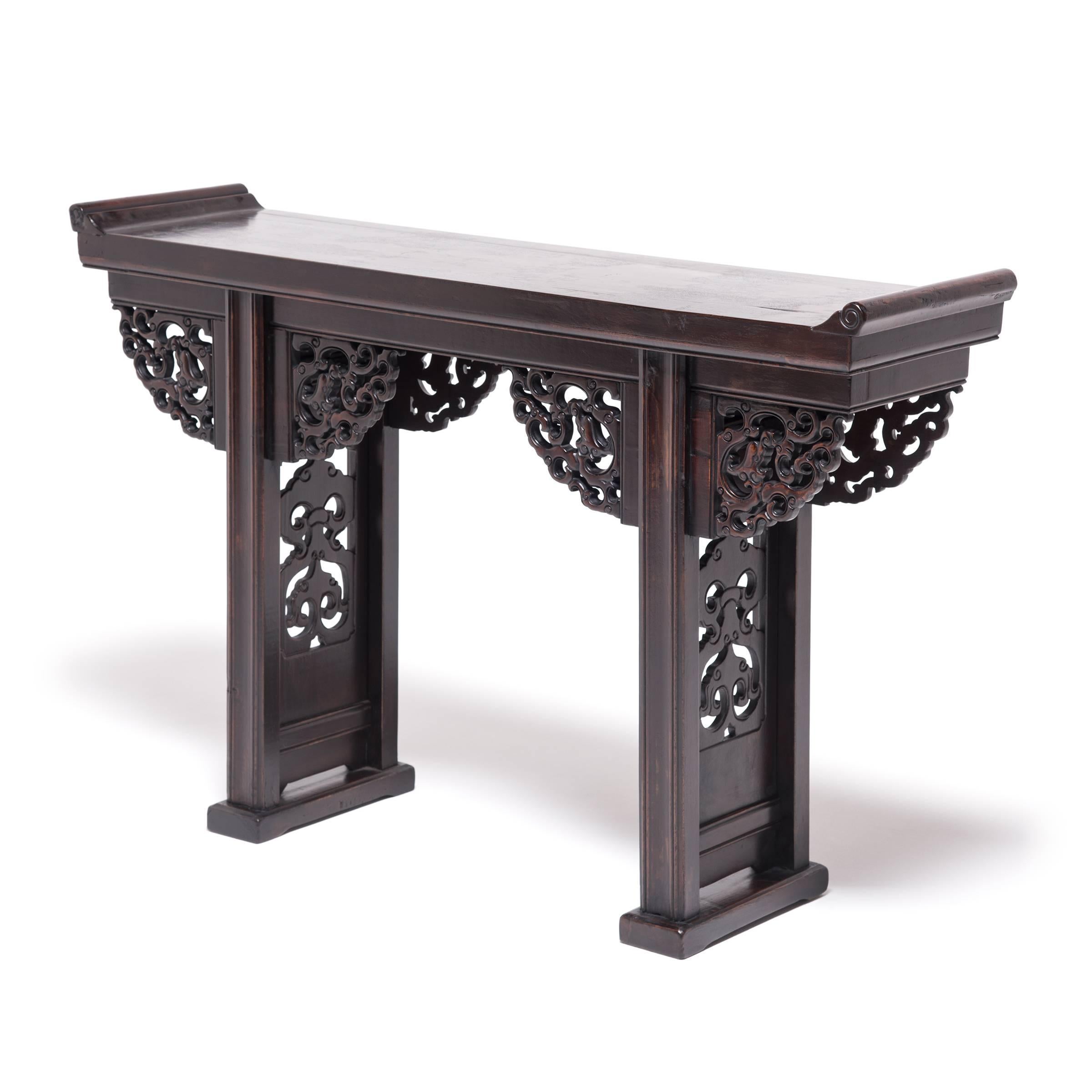 Six elaborately carved dragons in still this dramatic altar table with potent and auspicious power. Providing delicate counterpoint to the table’s strong Silhouette - defined by everted ends and trestle legs - the intricate carvings bring exuberant