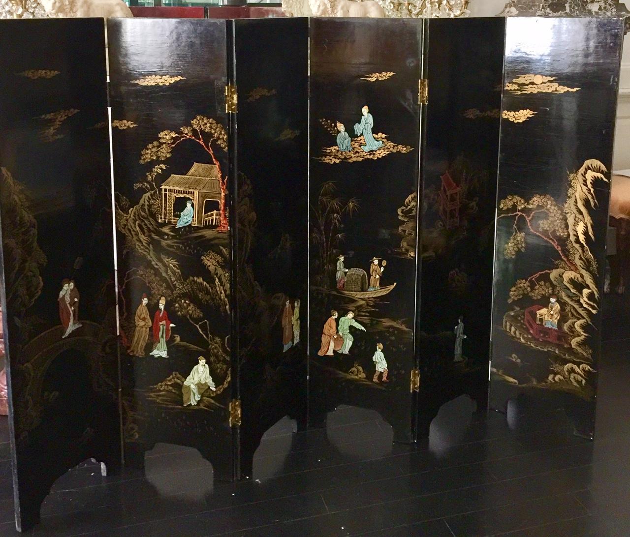 Chinese six-panel lacquer screen.
This lovely and versatile screen is in the great style of Coco Chanel who loved to decorate with Coromandel screens.
One front on a black background, depicting pagodas, various figures, a boat, gardens and flora,