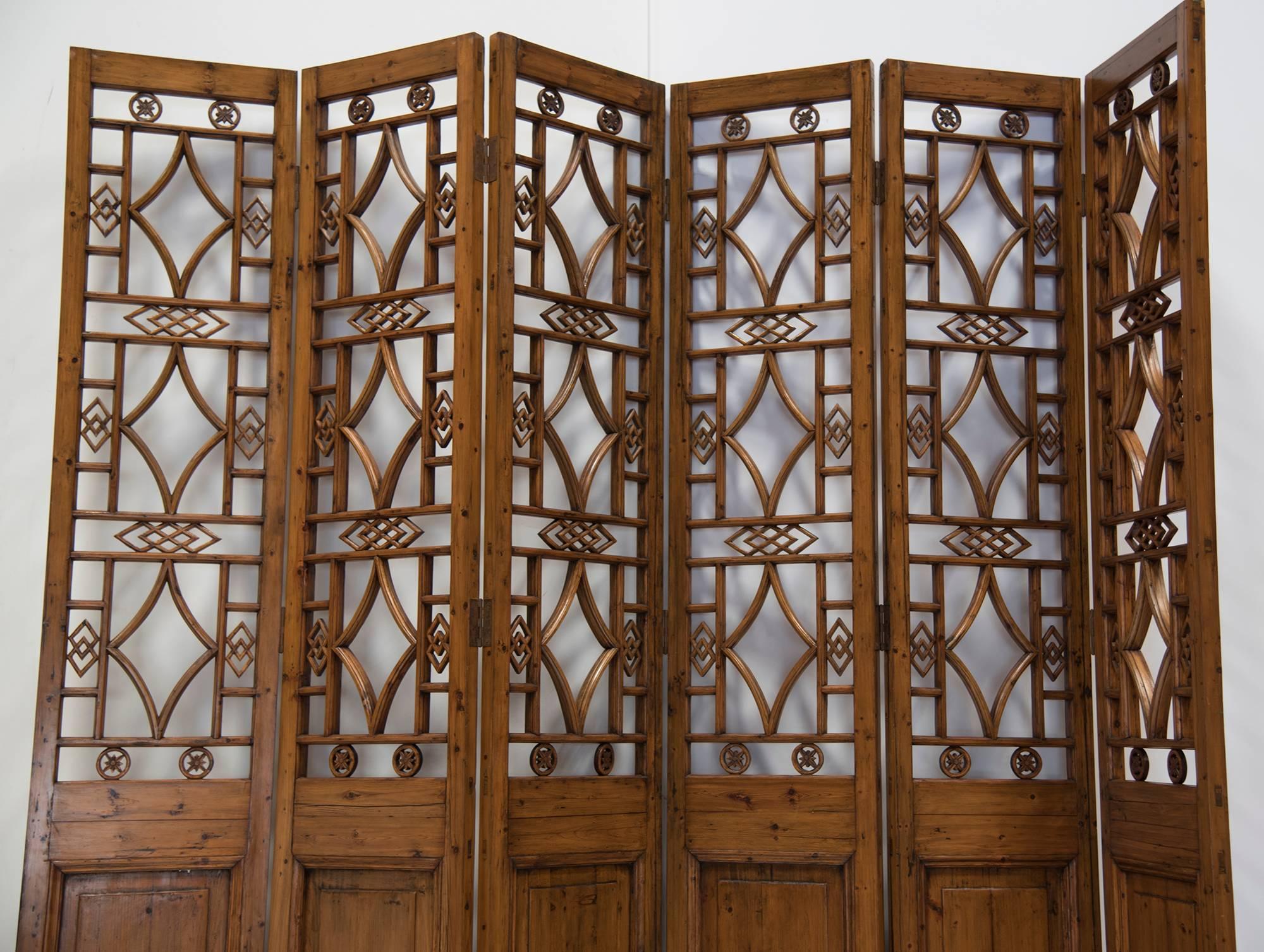 An early 20th century Chinese framed lattice-work six-panel screen with upper sections in openwork geometric motif. An exquisite design in pristine condition will work wonders for any large room of your home. Panels are easily arranged and hinges