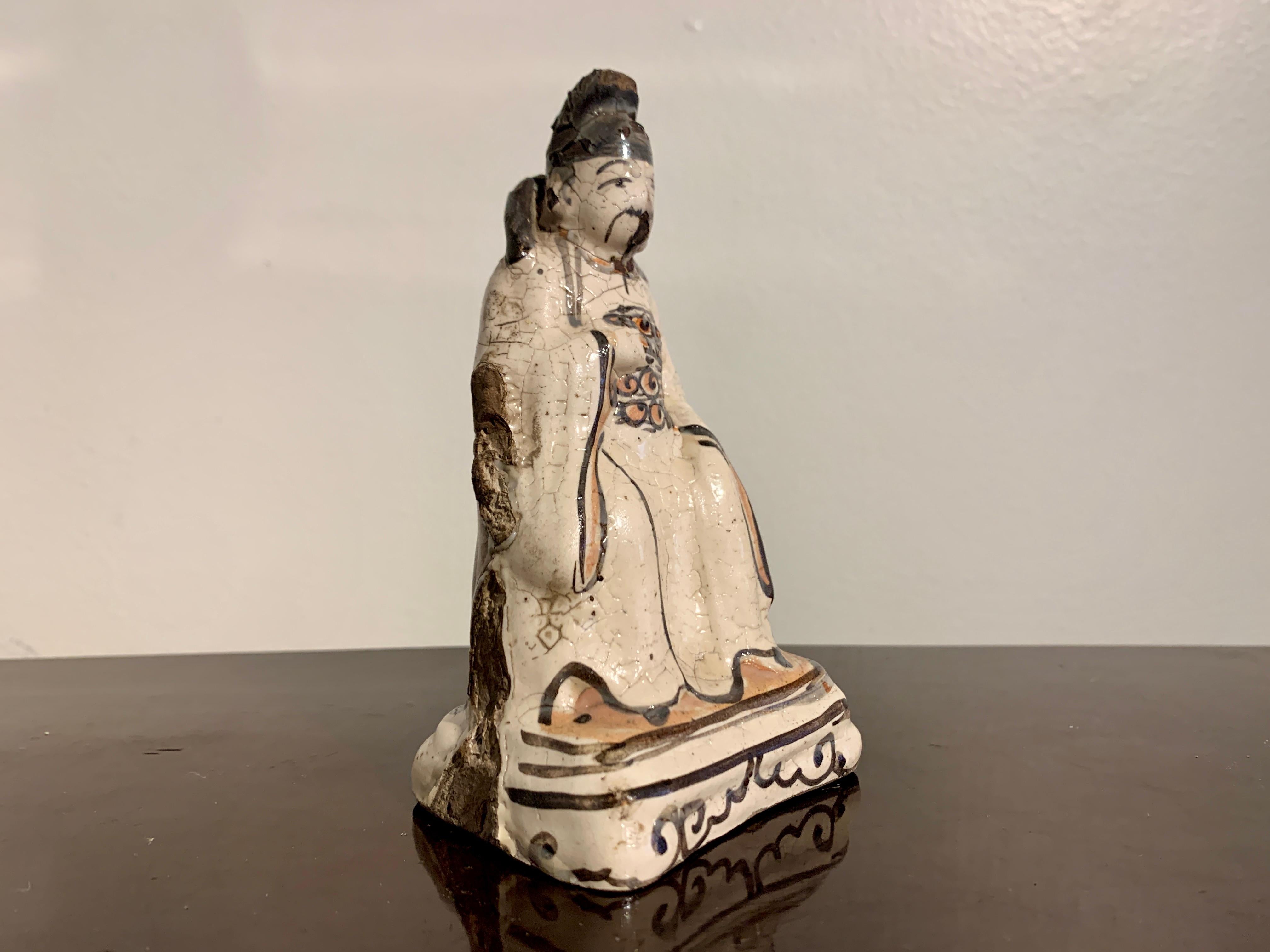 A small and charming Chinese cizhou ware glazed pottery figure of a Taoist deity or official, Song to Ming Dynasty, 13th - 15th century, China, ex. Christie's NY. 

The small figure modeled as an mustachioed official seated upon a raised throne.