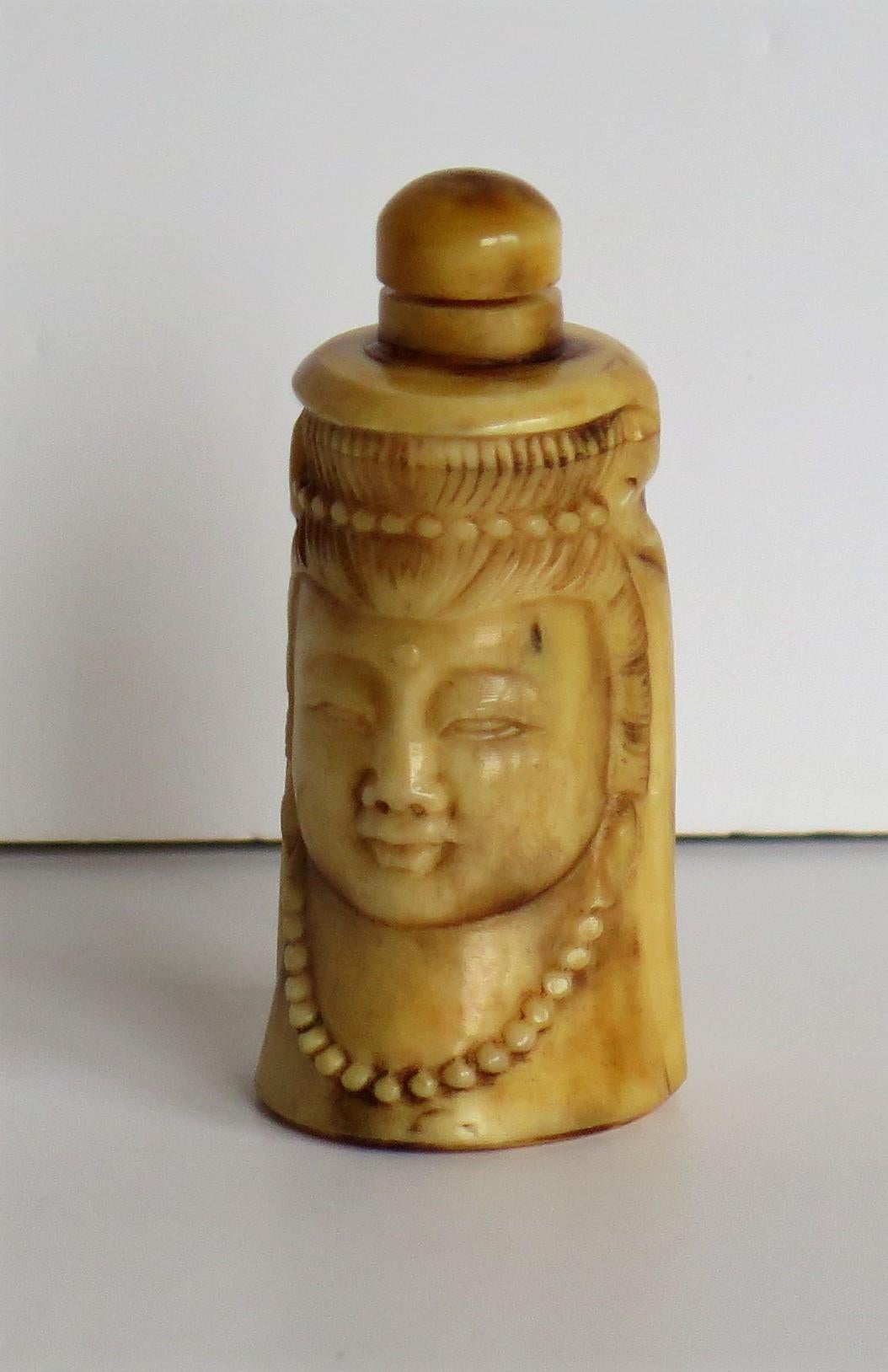 This is a very good Chinese hand carved Bone Snuff Bottle depicting Guanyin which is an East Asian Buddhist Deity. We date this piece to the earlier part of the 20th century, circa 1930s. 

The bottle is made of bovine bone which has a