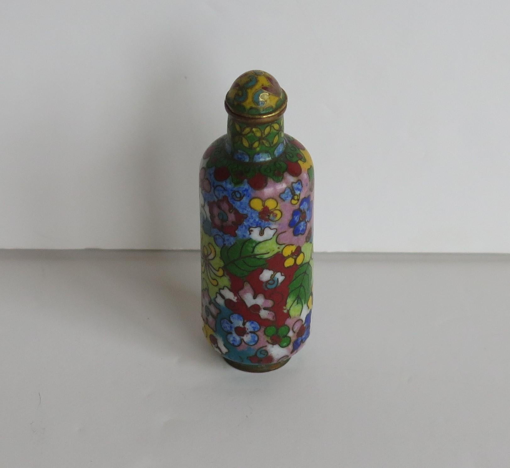 This is a very good example of a Chinese snuff bottle, made from cloisonne´ with hand enamelled decoration depicting 100 / 1000 flowers decoration, with a spoon top, all dating to the 19th Century Qing period, circa 1870. 

The bottle is