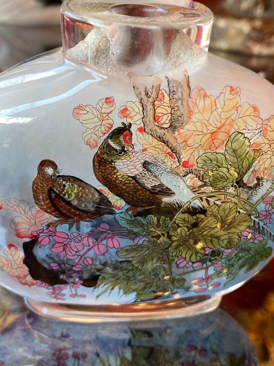 Magnificent Chinese snuffbox, covered in painted glass inside, with floral motifs as well as the representation of a couple of pheasants evolving in lush and colorful vegetation.

The pheasant is one of the twelve symbols that adorned the clothing