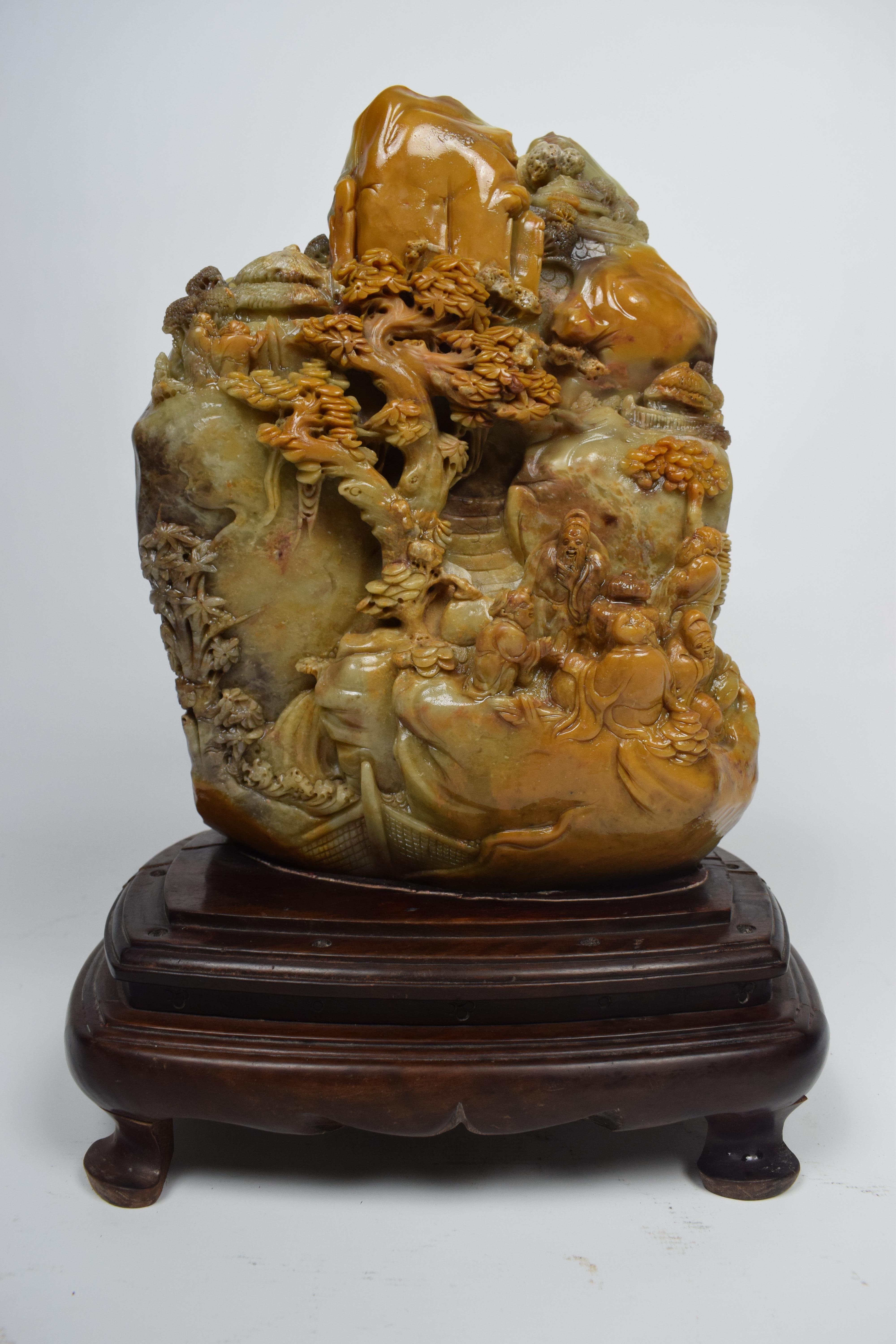 The Chinese yellow soapstone carving from the mid-20th century is depicting a village scene, is a stunning piece of art with intricate details and cultural significance. Yellow soapstone is a popular material for carving in China due to its smooth