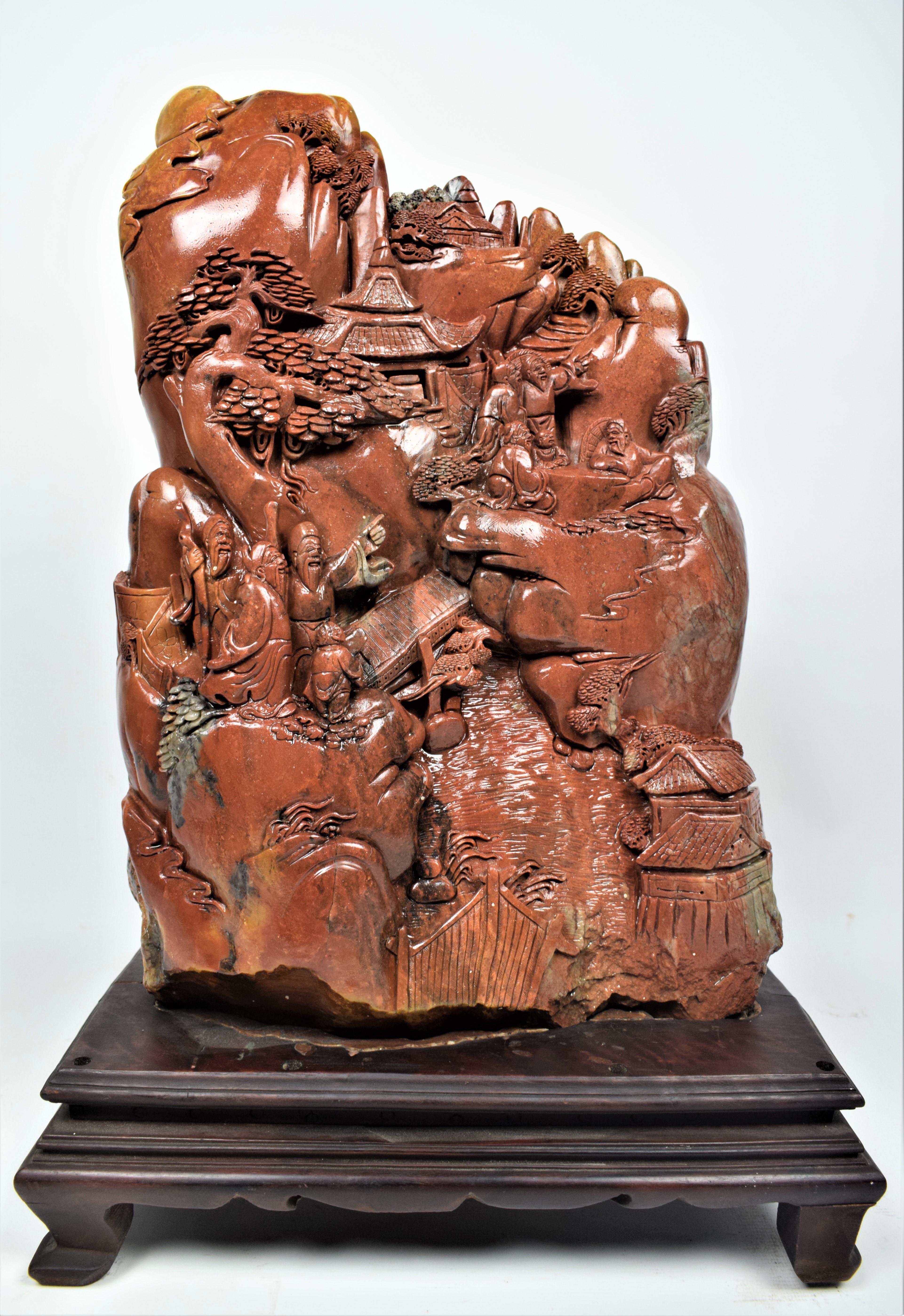 The Chinese soapstone carving from the mid-20th century is depicting a village scene, is a stunning piece of art with intricate details and cultural significance. The carving showcases a traditional Chinese village with elements that reflect life