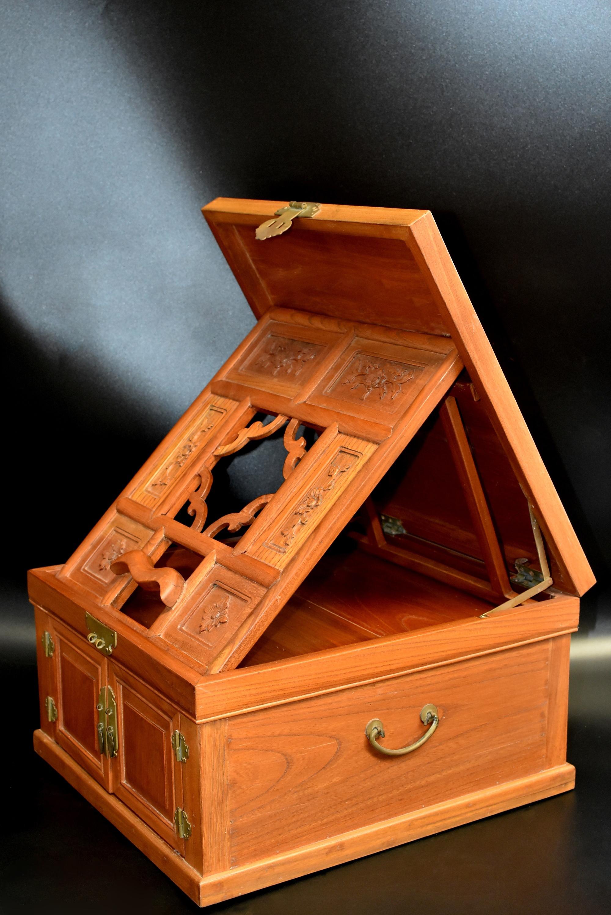 A beautiful, solid elm wood jewelry box with carved flowers and three full length drawers. The box opens to support the mirror stand. There are two positions for the mirror to be held. Box is 9