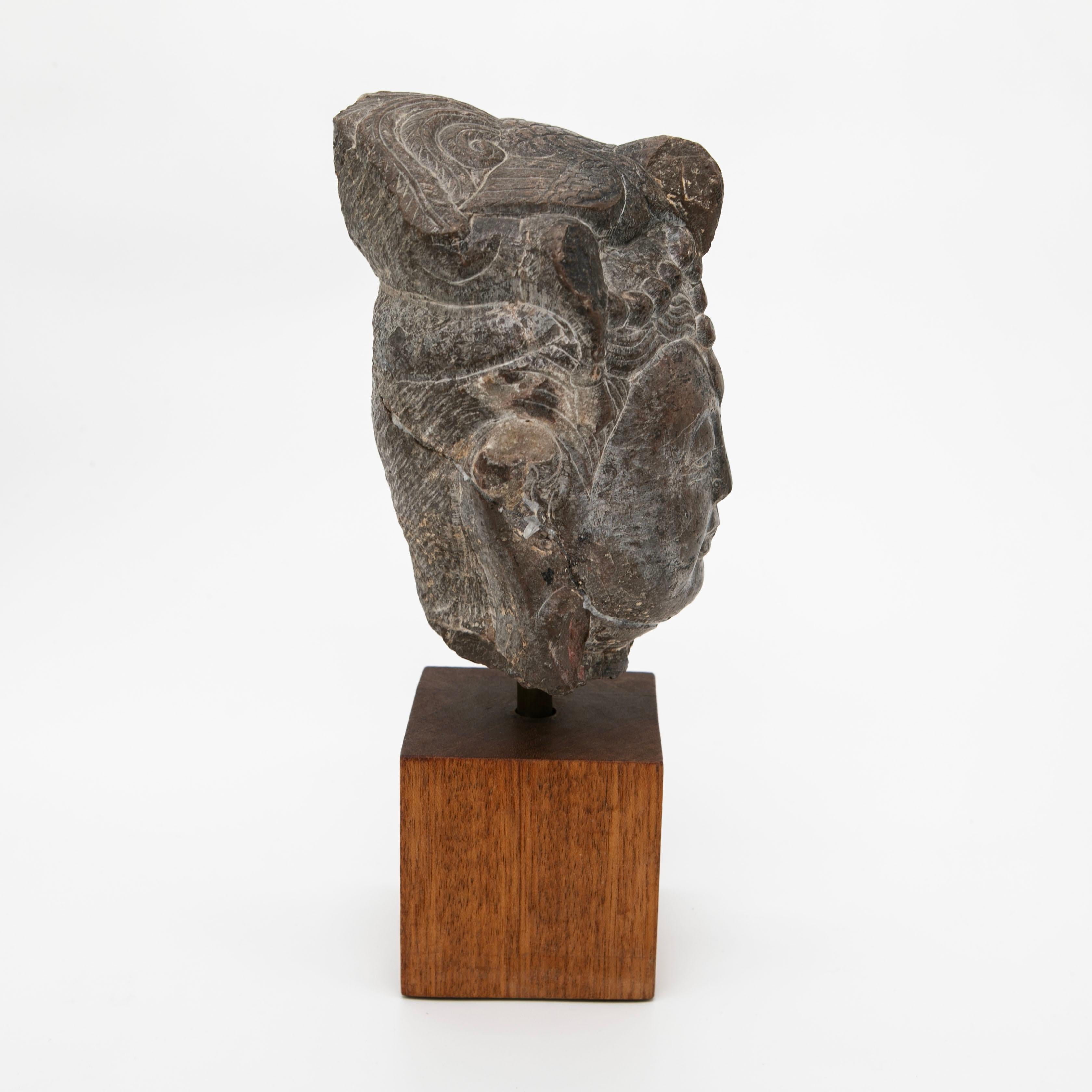 Testa di Buddha in pietra con una bella patina naturale dovuta all'età, risalente alla dinastia cinese Song,
La testa, che misura 18 x 12 x 12 cm,  è montato su una base di legno.

C'è una vecchia riparazione in cui la parte posteriore della testa è