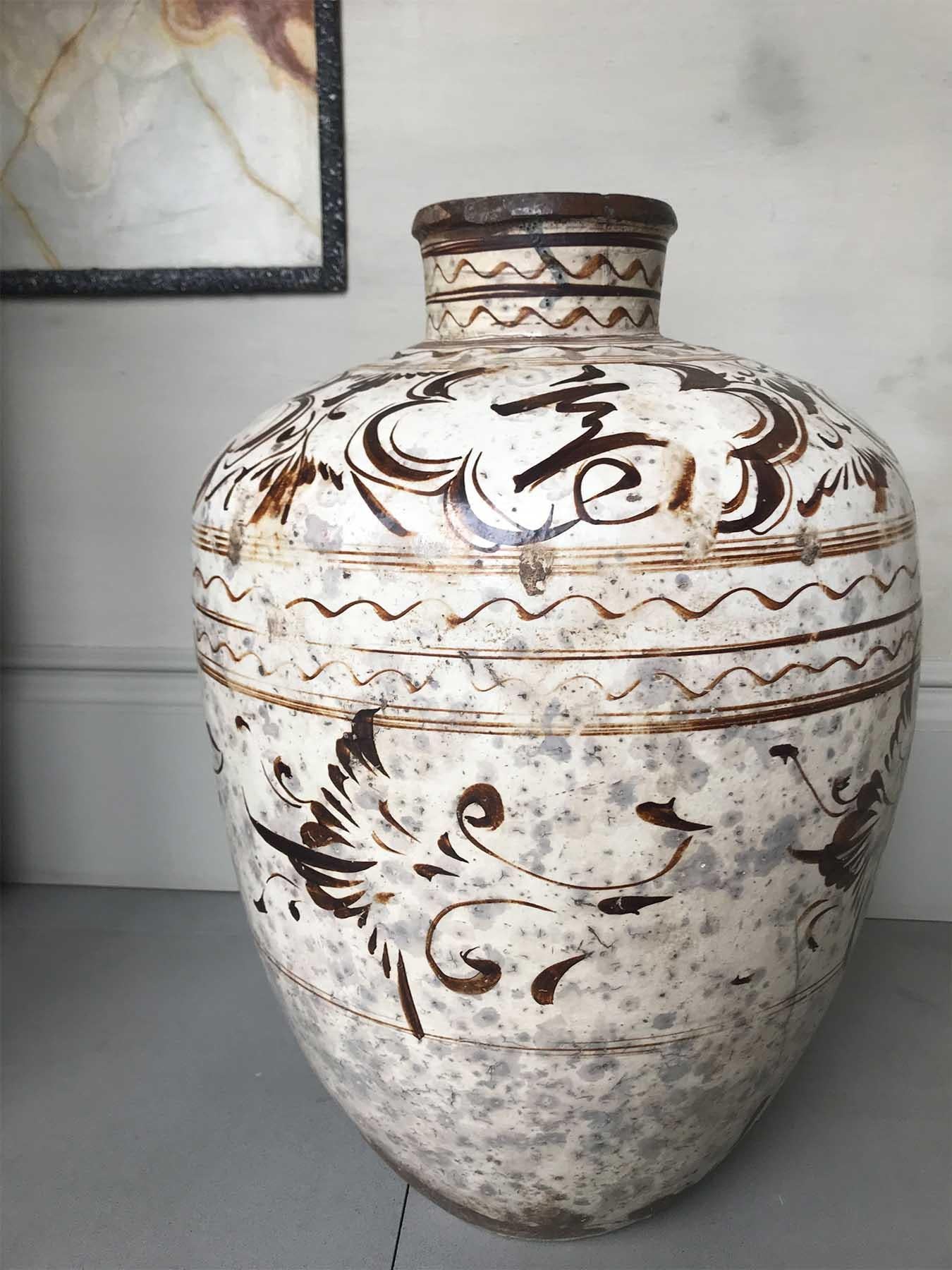 Chinese song Dynasty large storage container. Large tapering storage jar with short neck, body glazed with white ground, painted with brown foliate designs, shoulder decorated with five panels of Chinese characters.
