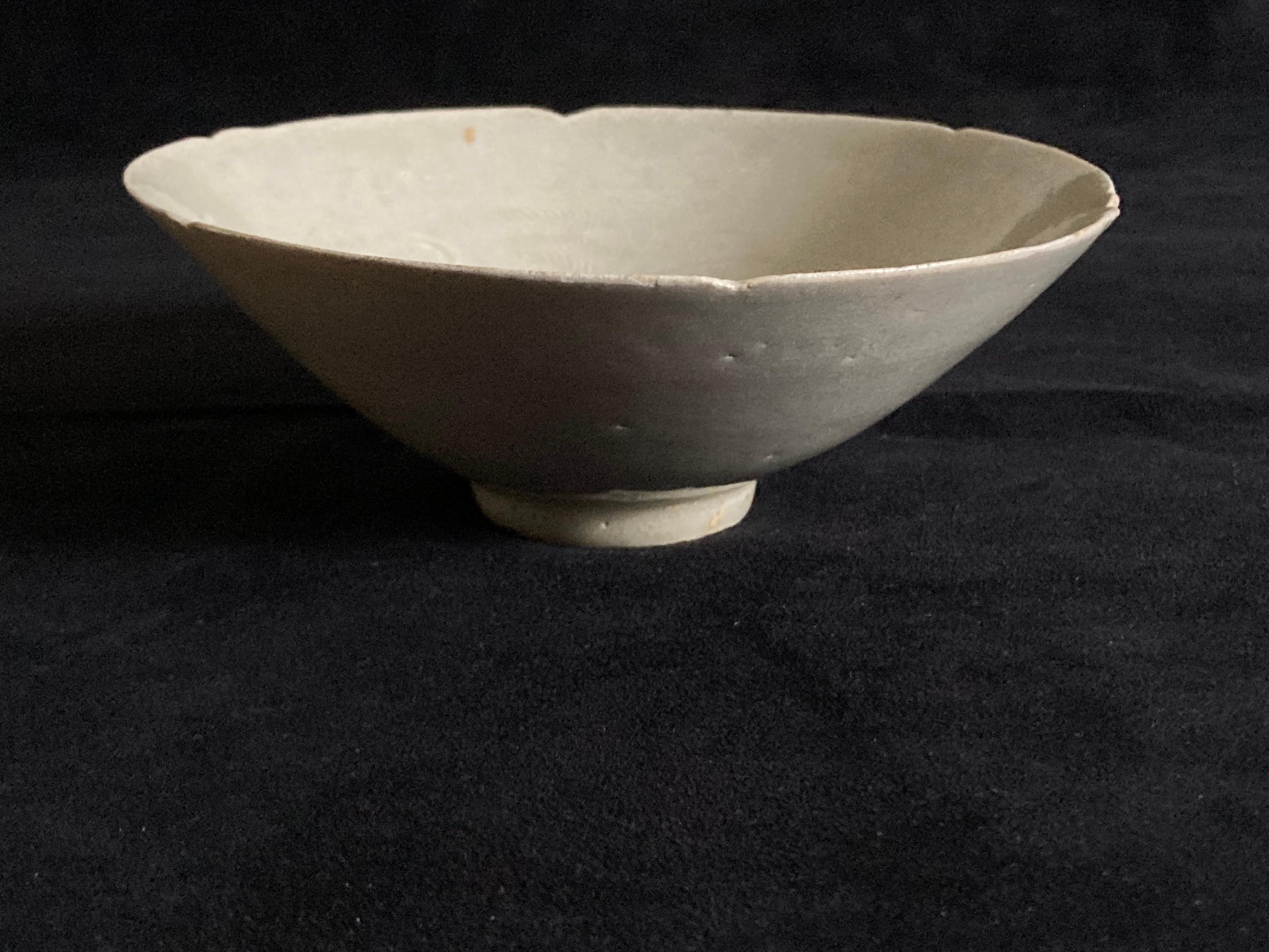A Chinese Song period celadon glazed bowl. Petal form rim and hand-carved decoration to the interior.

Really nicely thinly potted example with craquelure due to age.

Provenance: From a private London collection.