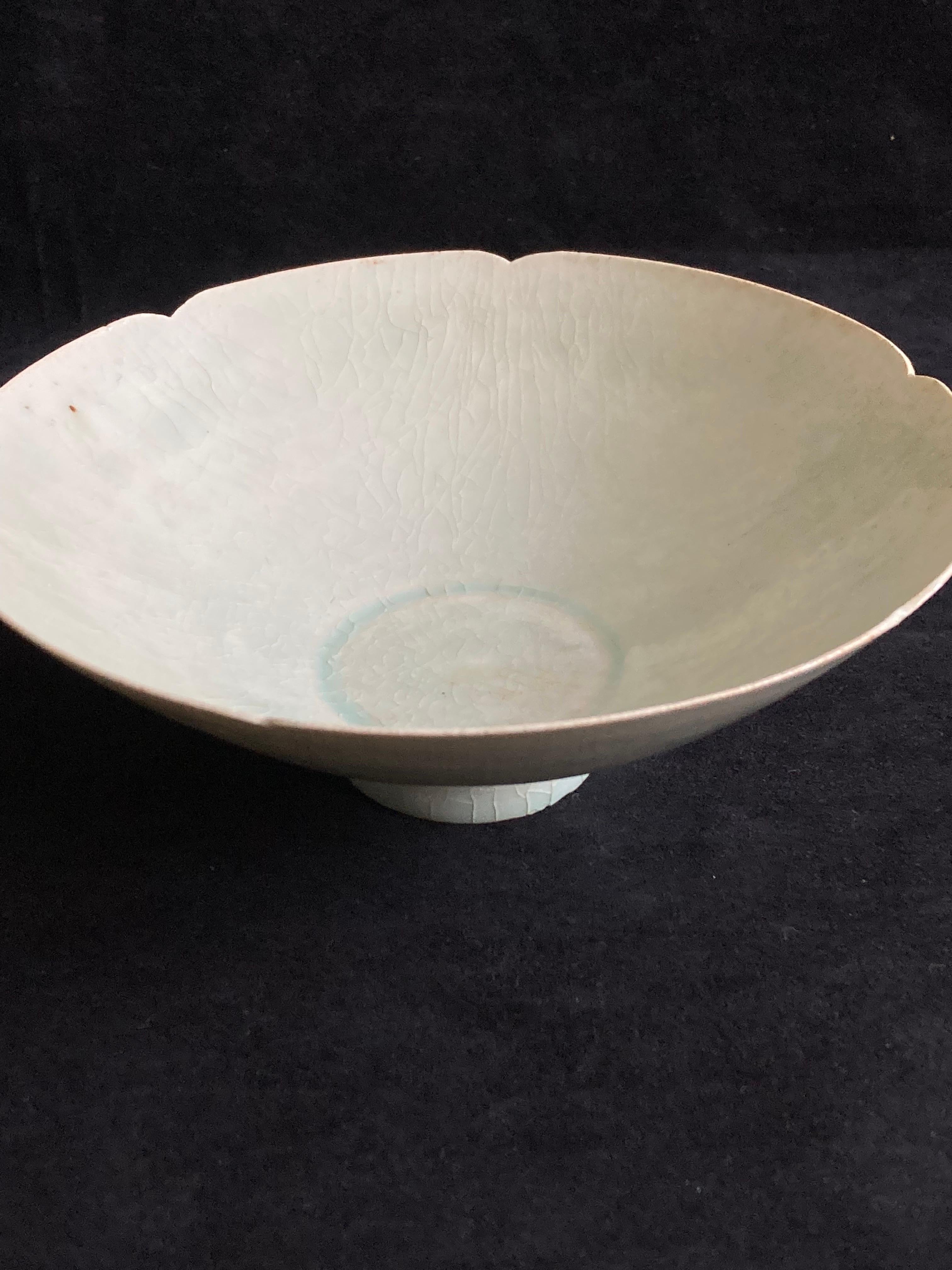 A Chinese Song period celadon glazed bowl. Petal form rim and hand-carved decoration to the interior.

Really nicely thinly potted example with craquelure due to age.

Provenance: From a private London collection.