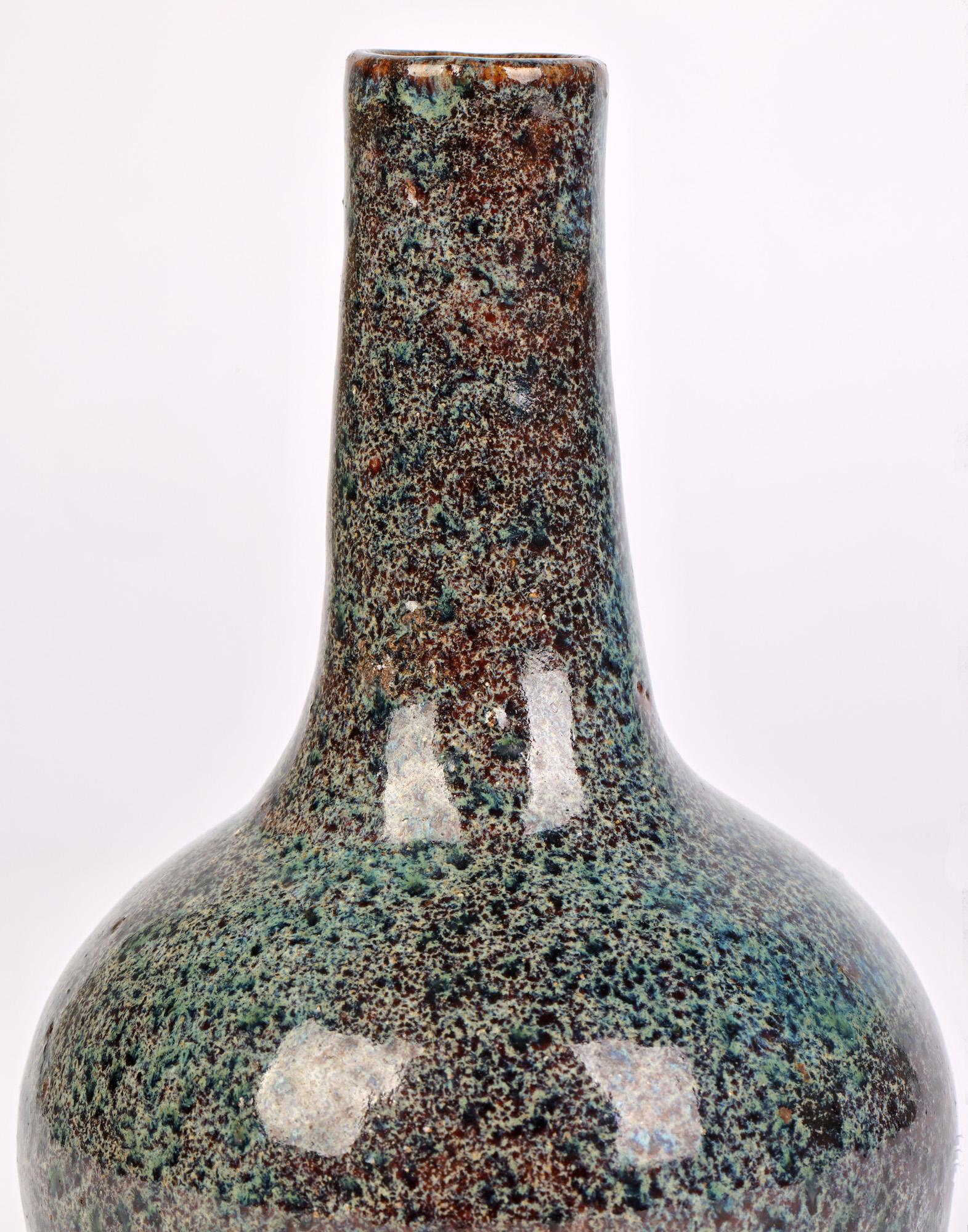 A fine quality Chinese onion shape bottle vase decorated in mottled glazes dating from the latter 19th or 20th century. The stoneware vase stands raised on a narrow round foot and has a round lower body with a tall slender neck with simple round