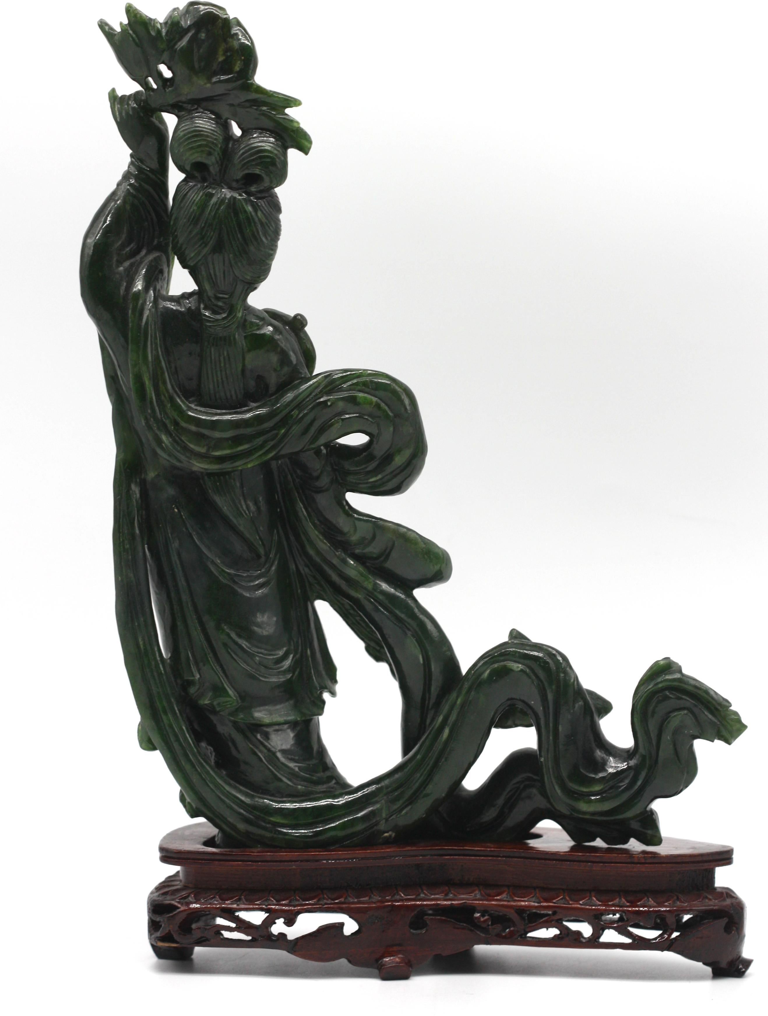 
Chinese Spinach Green Jade Figure of a Beauty
The lady in elegant attire with a flowing robe, her left-hand holds a floral blossom, in her right a fan, on a wood stand.
. Height 11 in., Width 8 in., Depth 1.75 in.