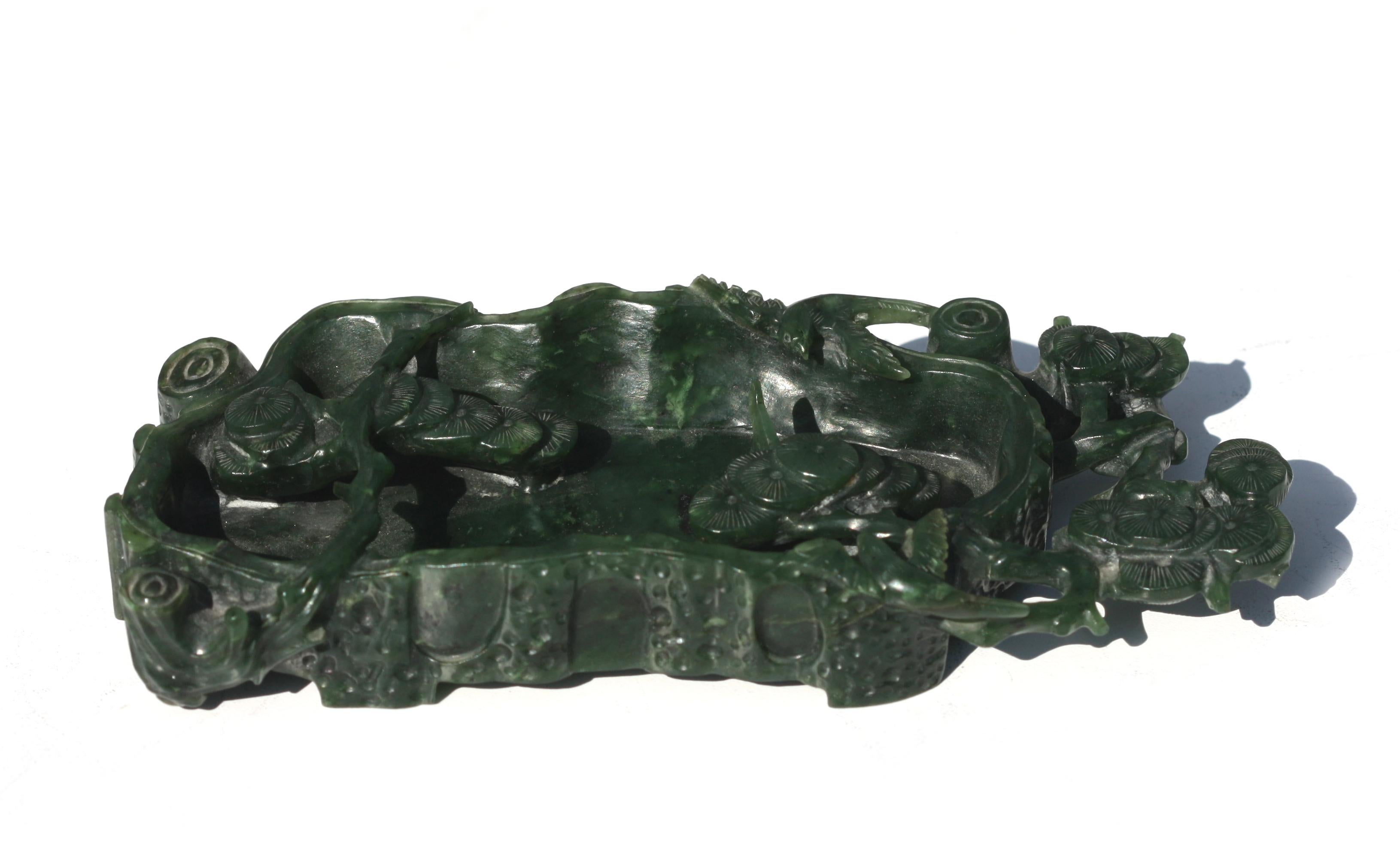 Chinese Spinach Jade Brush Washer
Depicting an asymmetrical rectangular rock pond, with blossoming lingzhi branches.
Height 1 in. (2.54 cm.), Width 6.75 in. (17.14 cm.), Depth 3 in. (7.62 cm.)