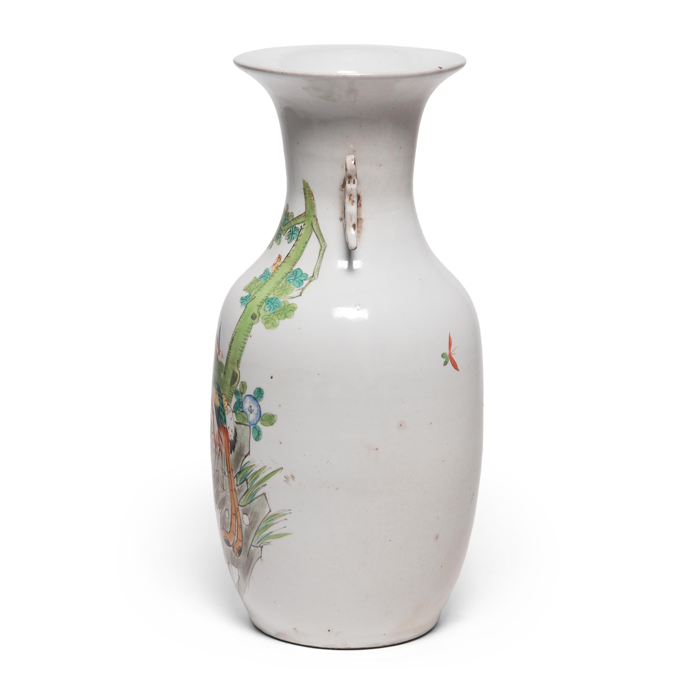 The phoenix tail vase form dates back as far as the bronze age and has remained a popular shape for its clean lines and graceful curves. Created in the early 20th century, this particular tall vase depicts a stylized phoenix in a colorful garden