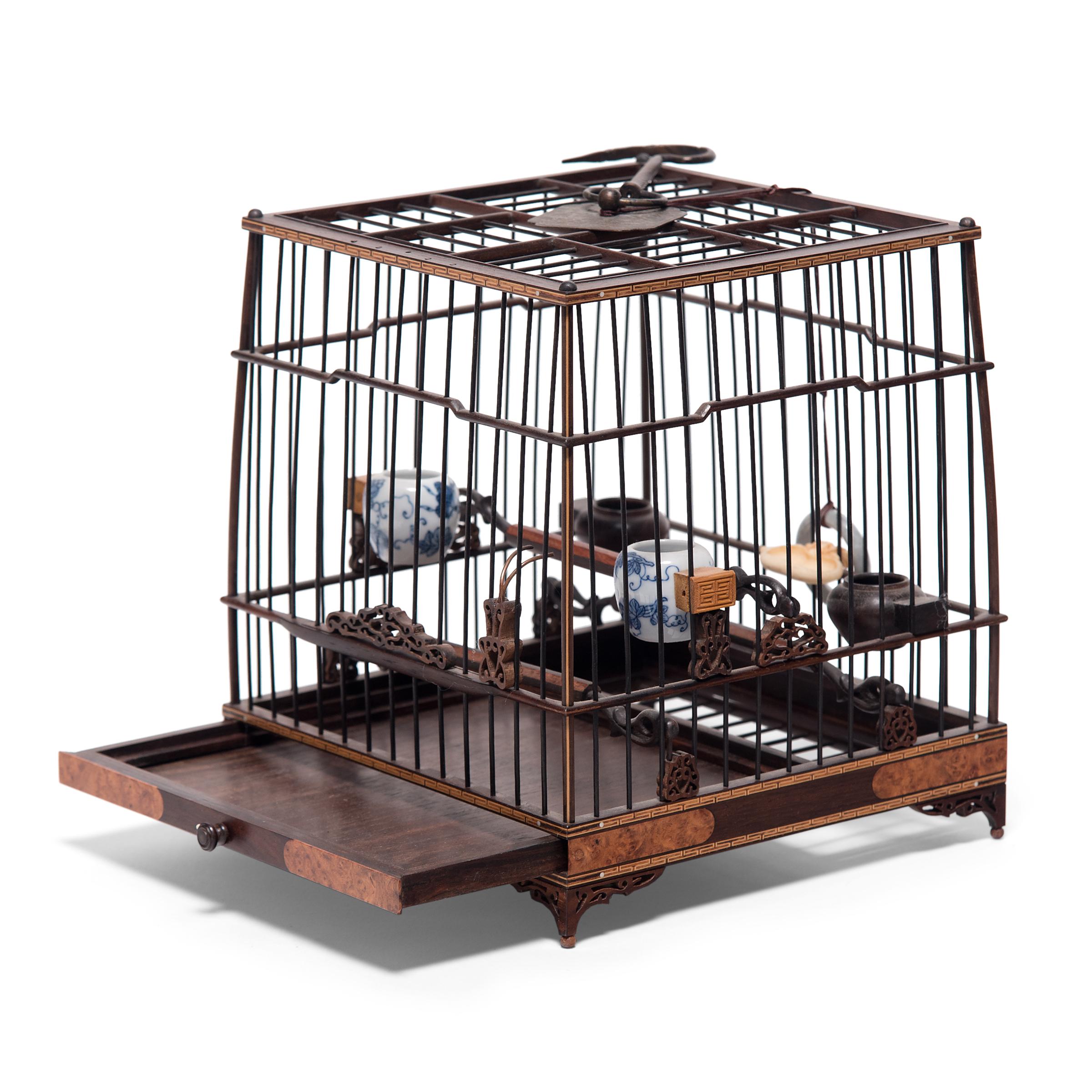 Perfectly proportioned and delightfully ornate, this wooden birdcage was once home to the pet of a Qing-dynasty aristocrat. Dated to the mid-19th century, the square birdcage is carefully assembled of thin rods of dark hardwood and trimmed with fine