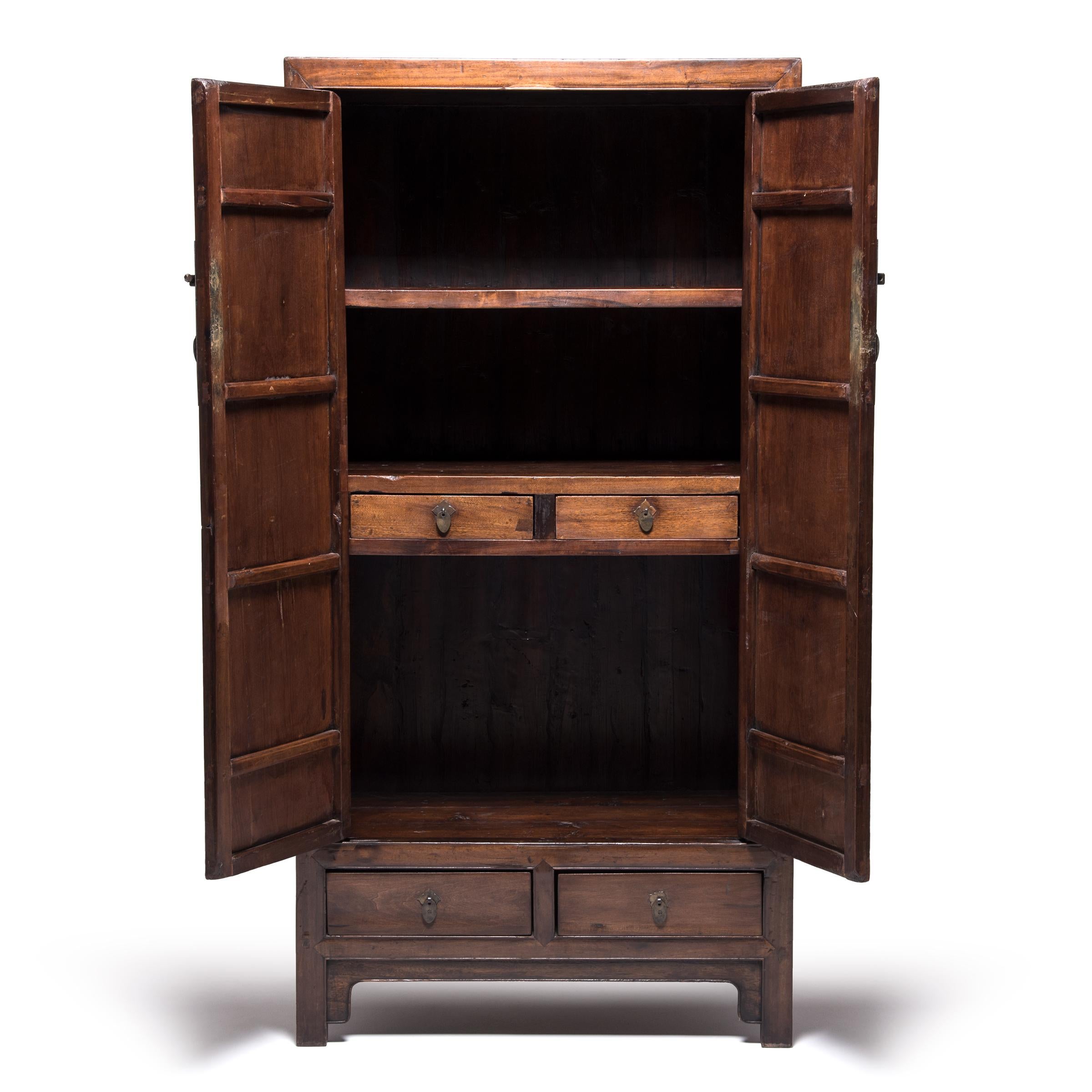 Although elaborate decoration became increasingly common in Qing-dynasty furniture design, the Ming-dynasty’s legacy of clean, elegant lines remained a powerful influence as seen in this statuesque scholar’s cabinet. Made of warm-colored cedar, the