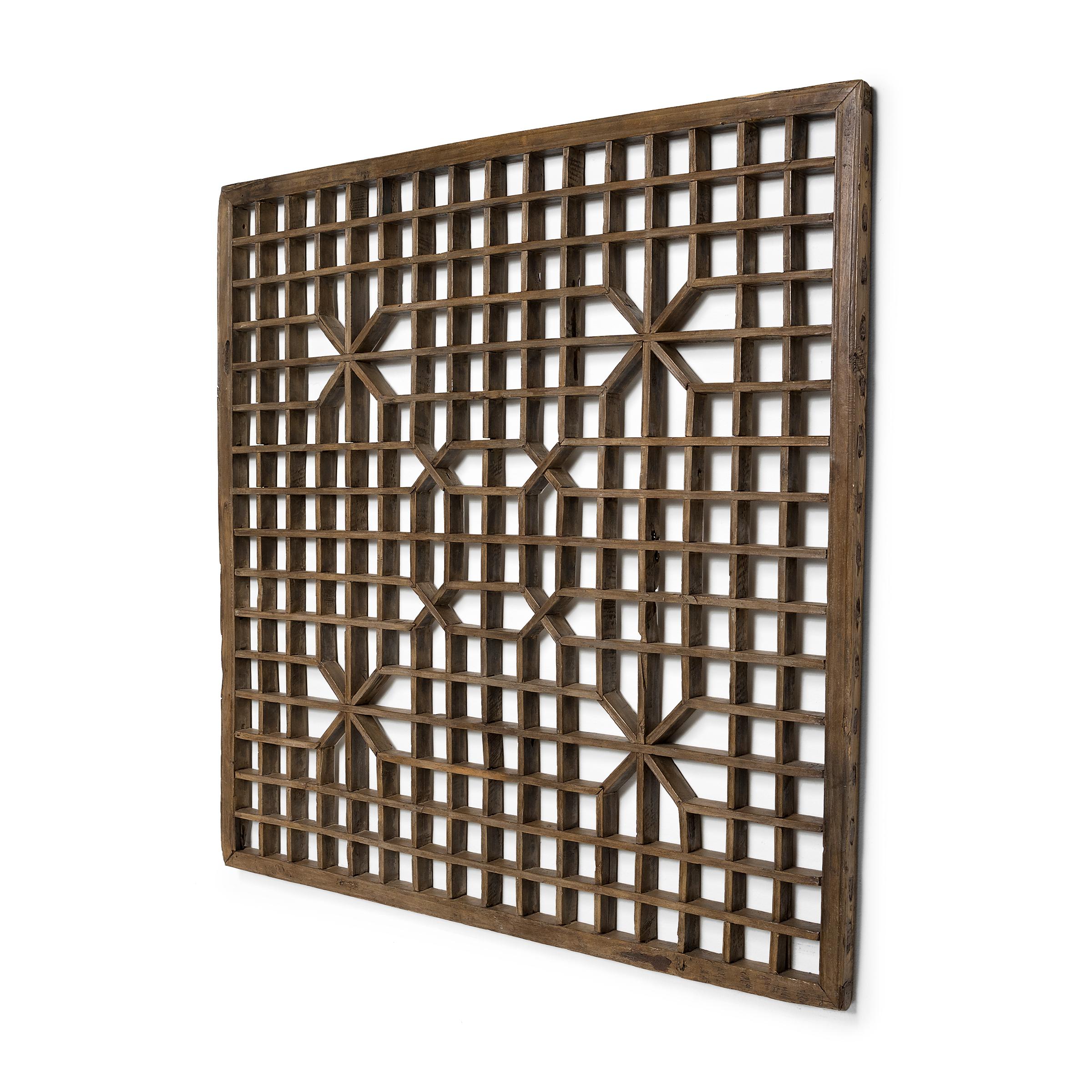 This early 20th century lattice window panel from China's Shanxi province likely originated in a traditional home with balanced interiors. Both functional and decorative, lattice windows allowed for fresh air and light to flow into a room while