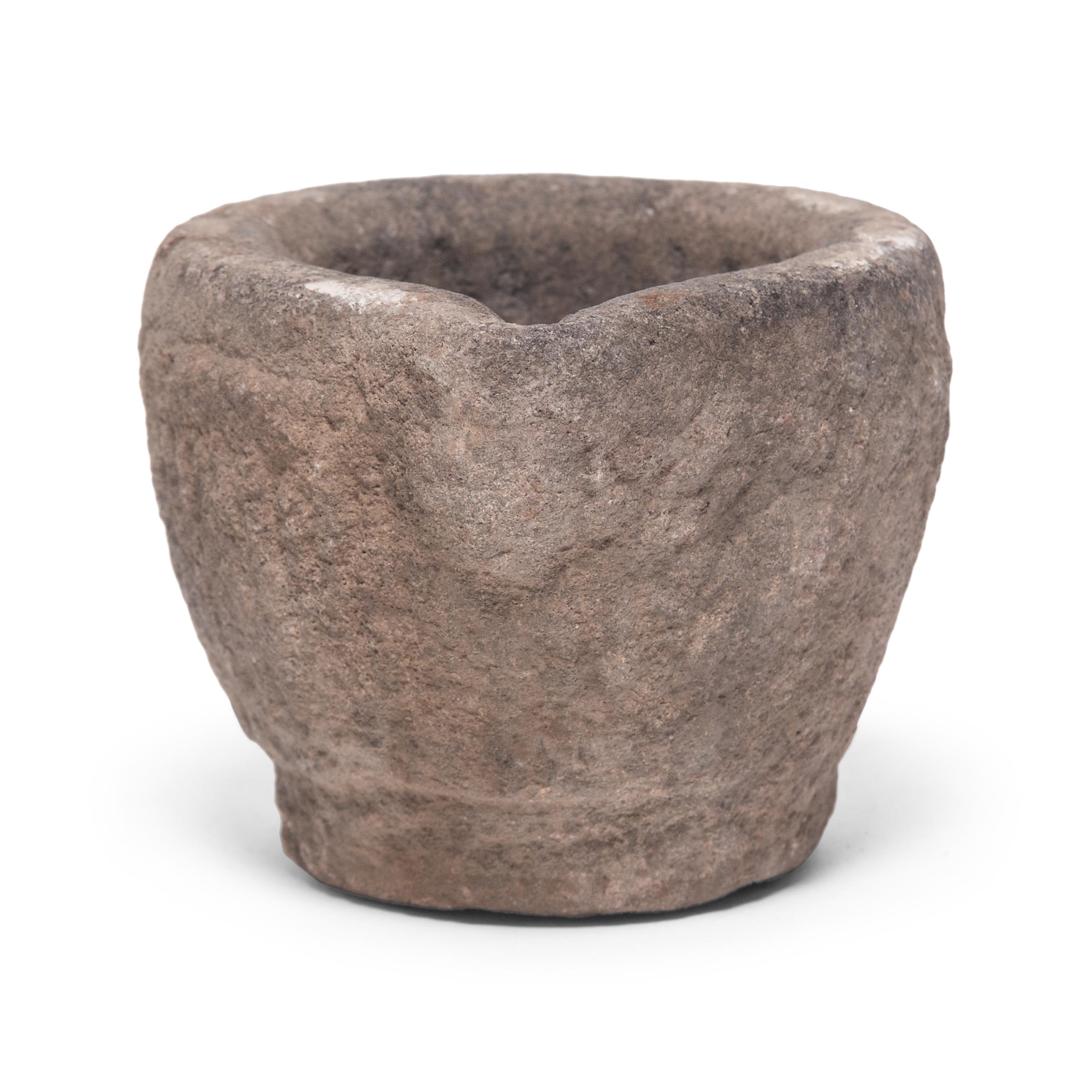 Hand carved from a single block of limestone, this round stone vessel is an early 20th century mortar once used daily in a provincial kitchen to grind herbs, spices, and other foods. Used as a decorative vessel or tabletop planter, the mortar's