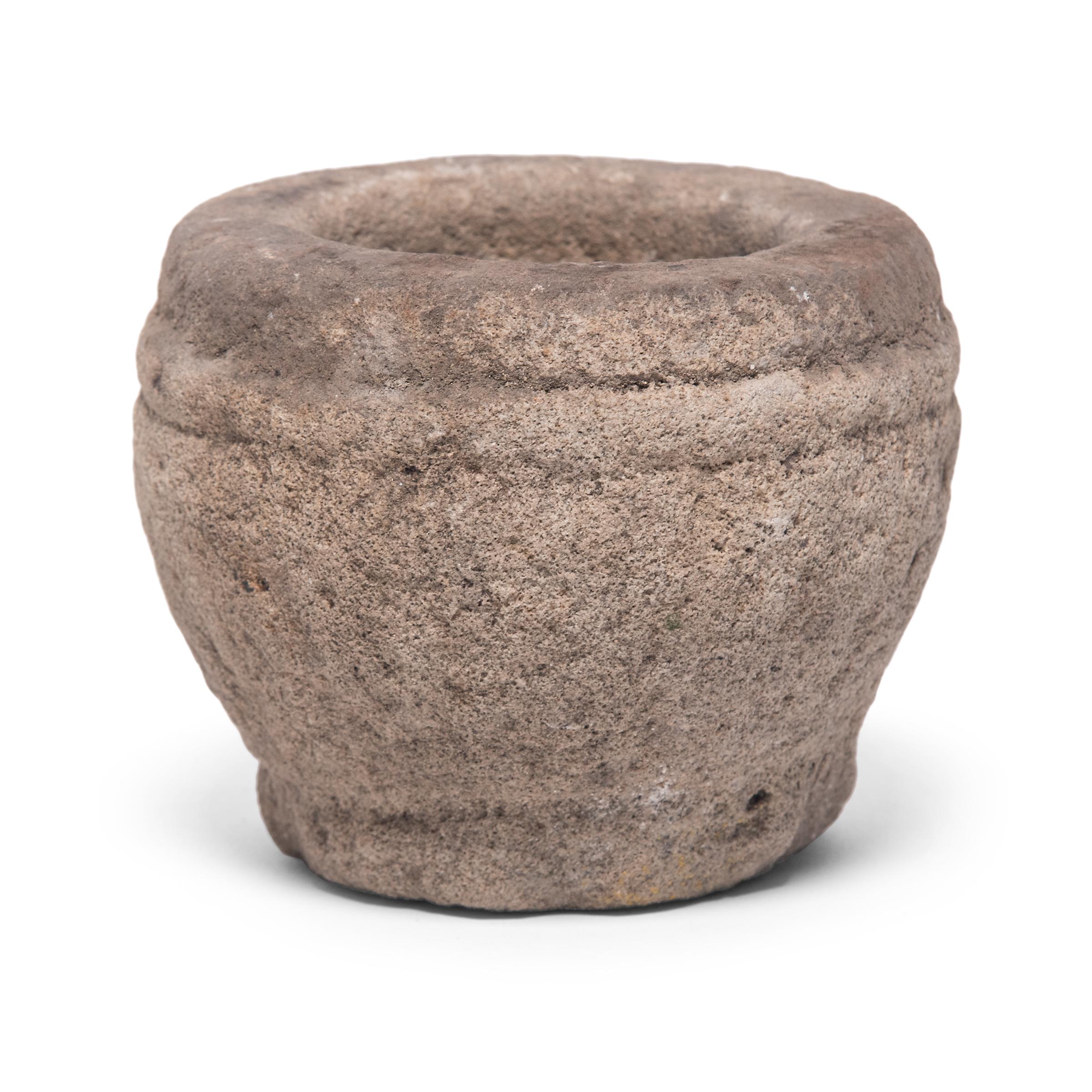 Hand carved from a single block of limestone, this round stone vessel is an early 20th century mortar once used daily in a provincial kitchen to grind herbs, spices, and other foods. Used as a decorative vessel or tabletop planter, the mortar's