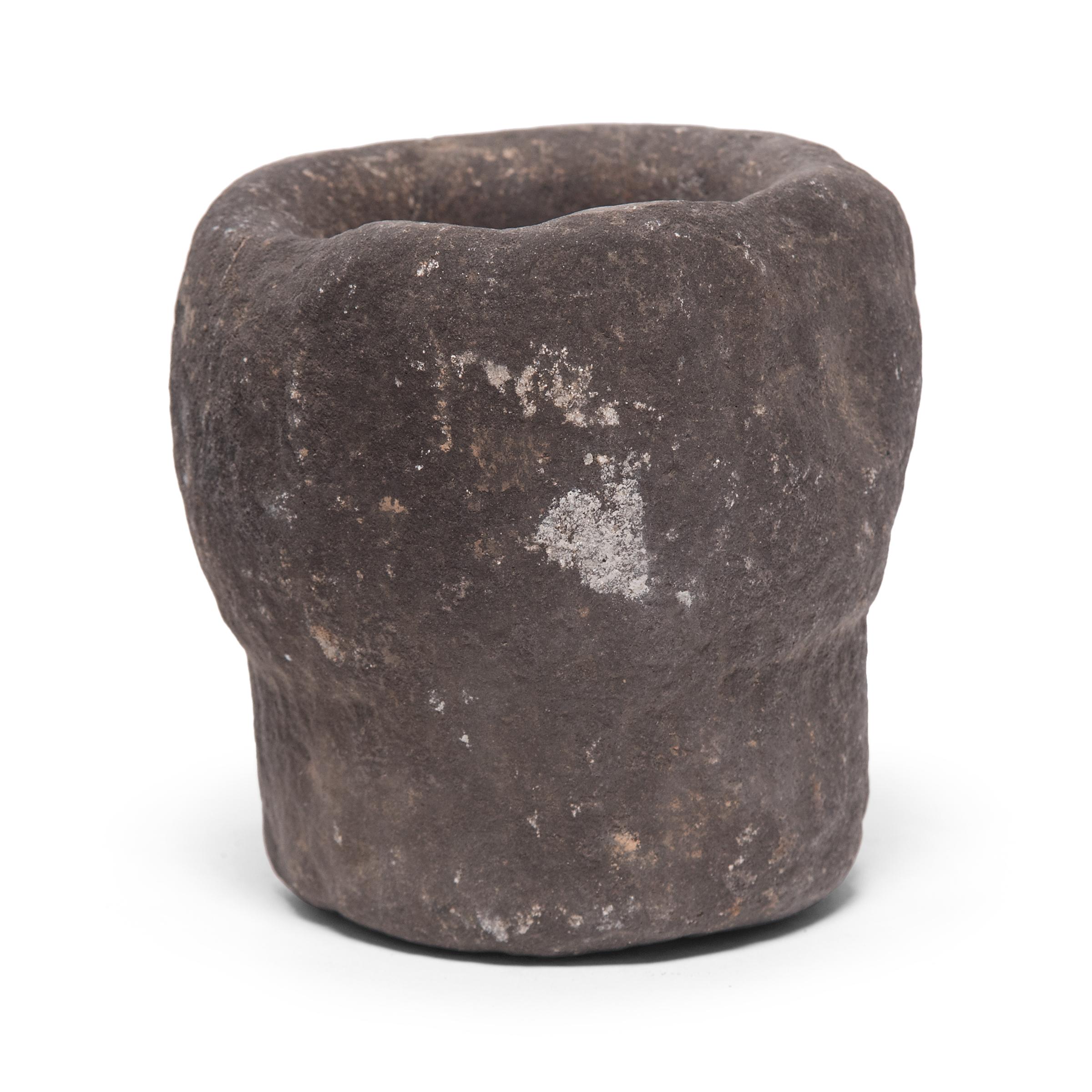 Hand carved from a single block of limestone, this round stone vessel is an early 20th century mortar once used daily in a provincial kitchen to grind herbs, spices, and other foods. Used as a decorative vessel or tabletop planter, the mortar's