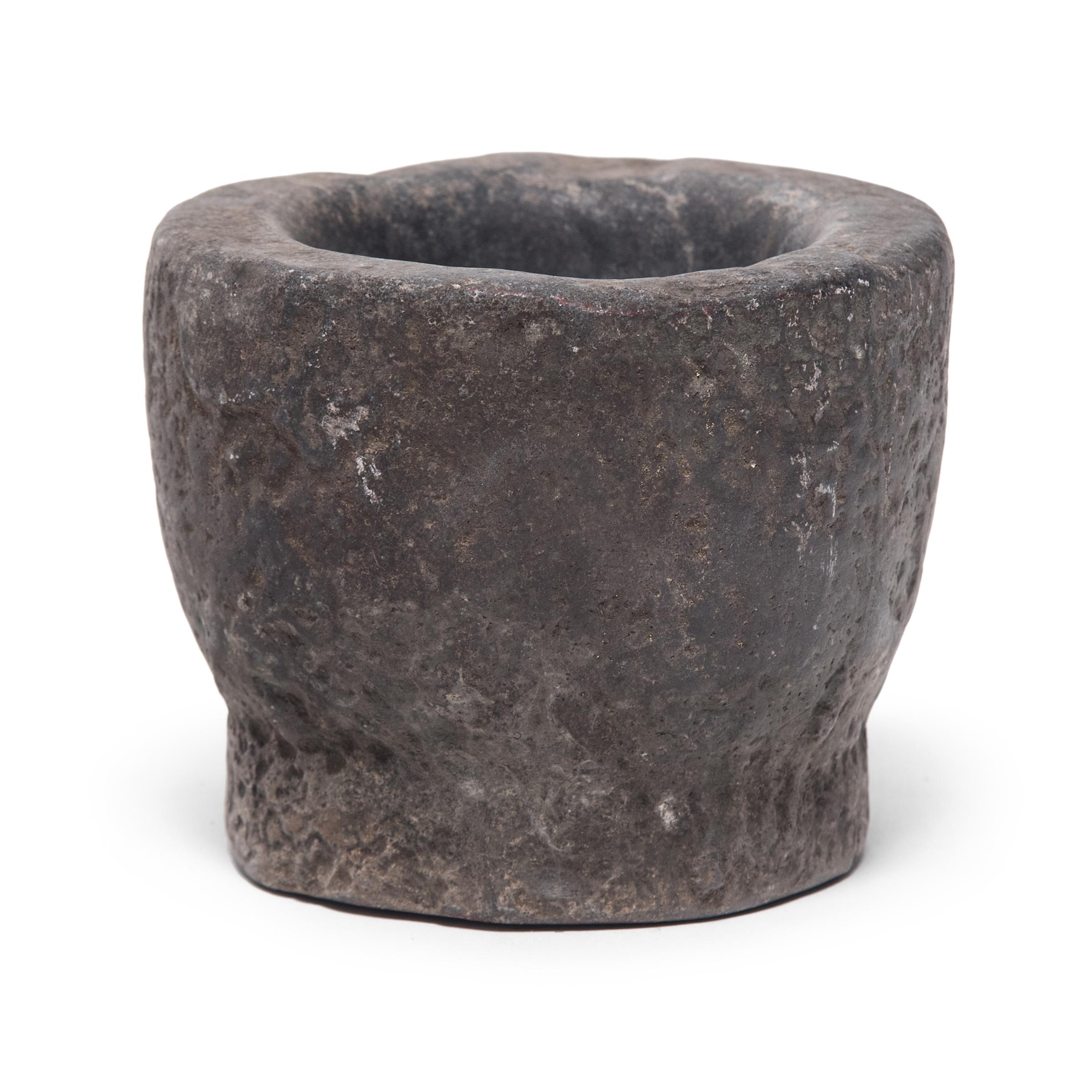 Hand carved from a single block of limestone, this round stone vessel is an early 20th century mortar once used daily in a provincial kitchen to grind herbs, spices, and other foods. Used as a decorative vessel or tabletop planter, the mortar's