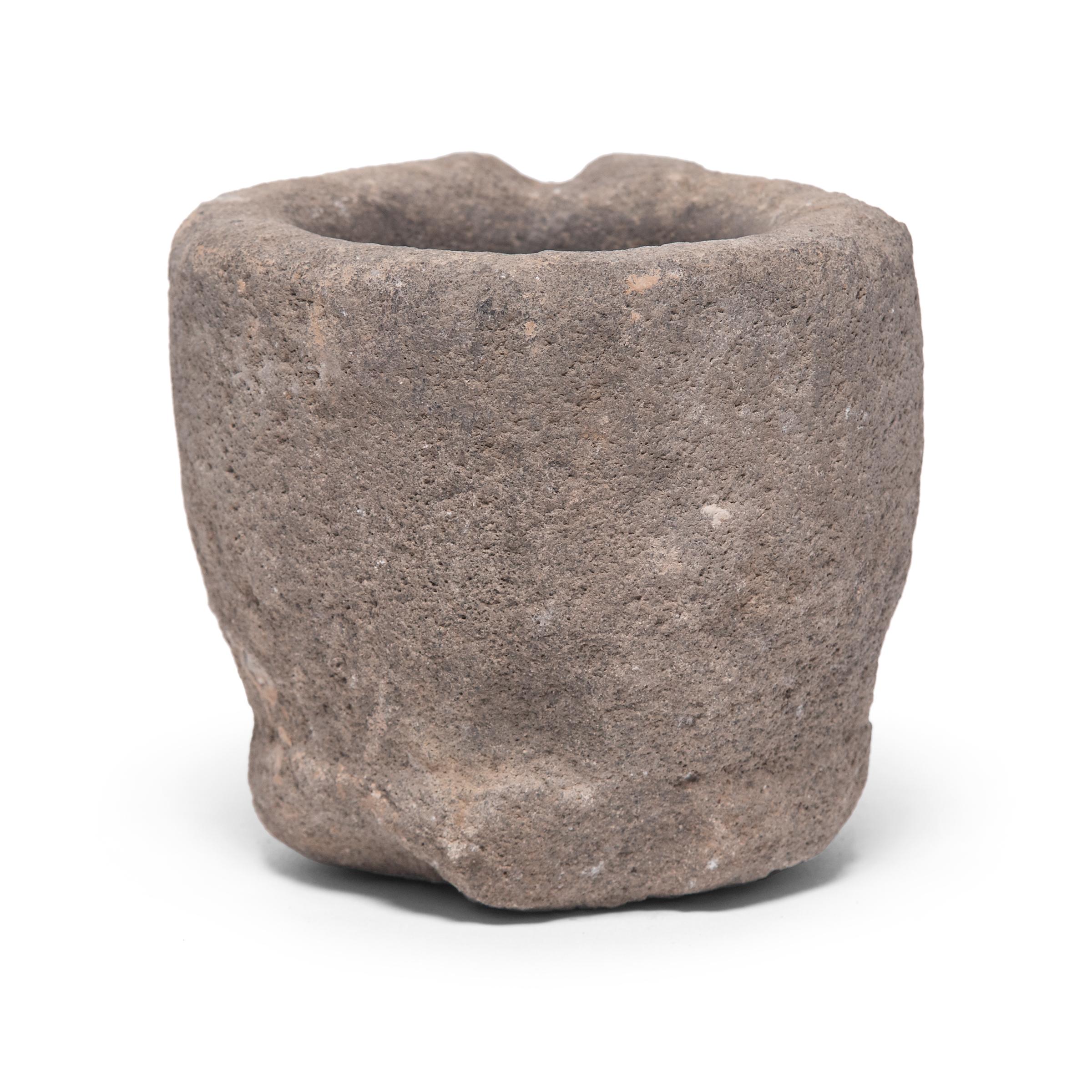 Hand carved from a single block of limestone, this round stone vessel is an early 20th century mortar once used daily in a provincial kitchen to grind herbs, spices, and other foods. Used as a decorative vessel or tabletop planter, the mortar's