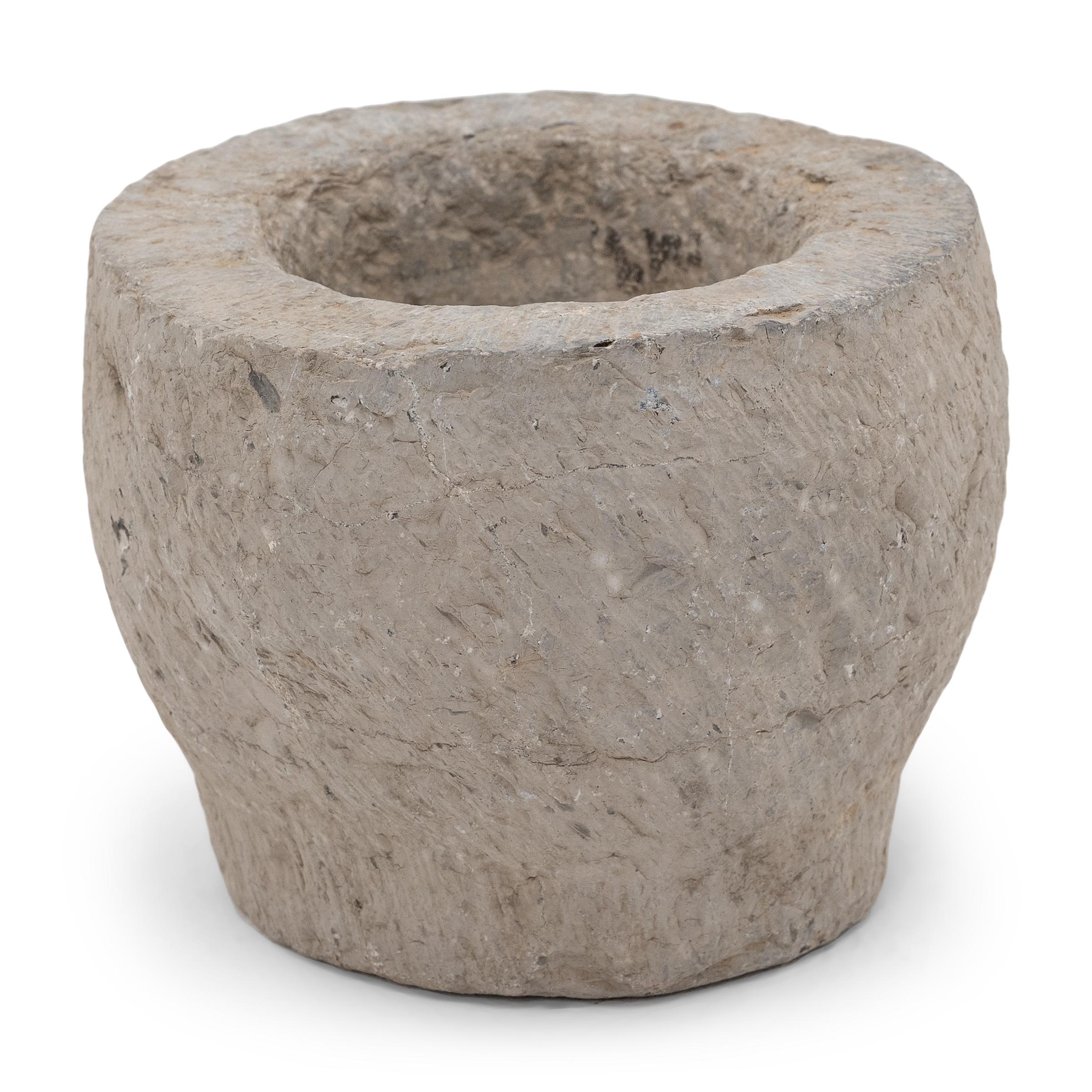 Sculpté dans un seul bloc de calcaire, ce récipient en pierre est un mortier datant du début du XIXe siècle, utilisé autrefois pour broyer des épices, des herbes et d'autres condiments. L'extérieur rustique, ciselé à la main, est magnifiquement usé
