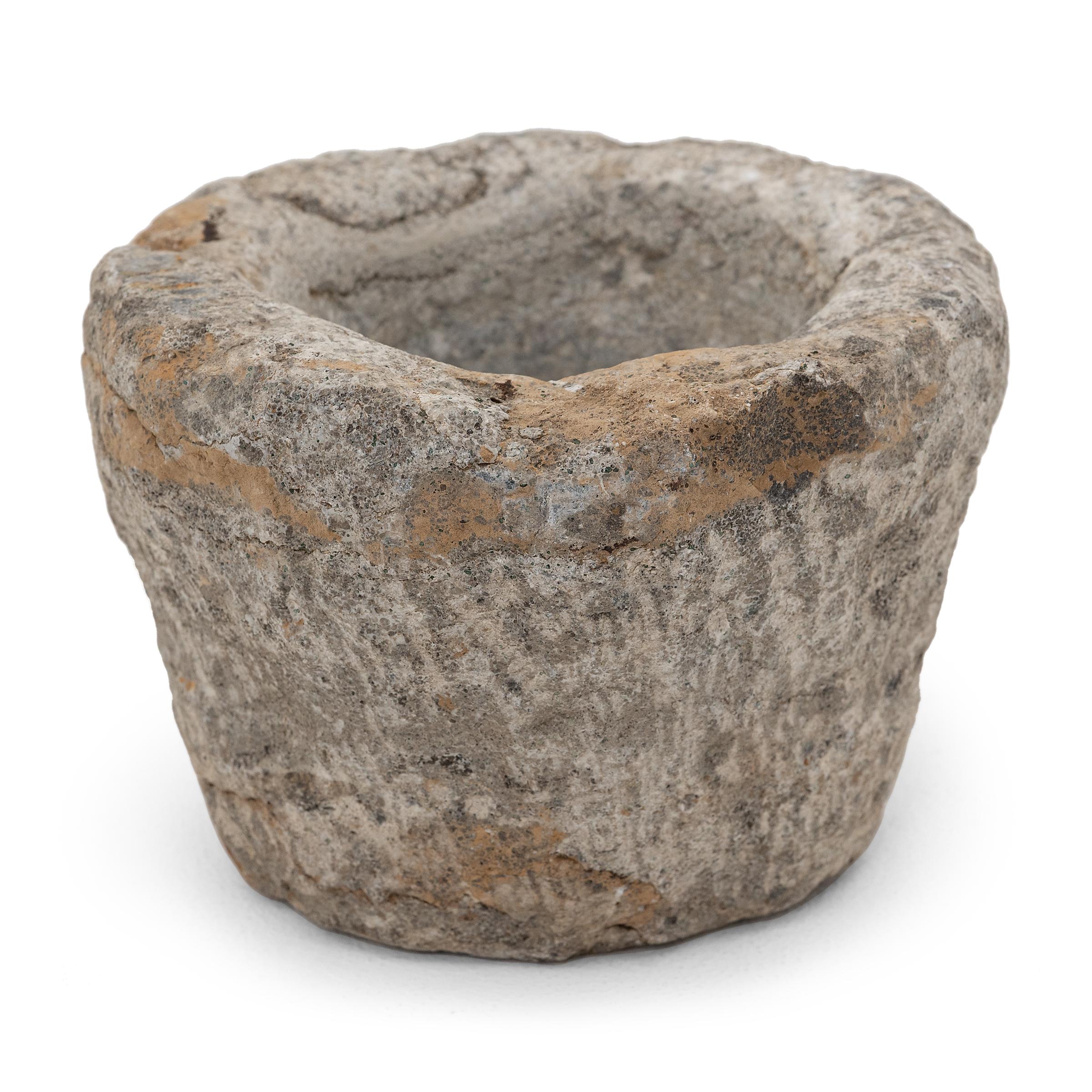 Ricavato da un unico blocco di granito, questo recipiente in pietra è un mortaio dell'inizio del XIX secolo utilizzato per macinare spezie, erbe e altri condimenti. L'esterno consumato dal tempo è decorato con segni di scalpello, mentre l'interno è