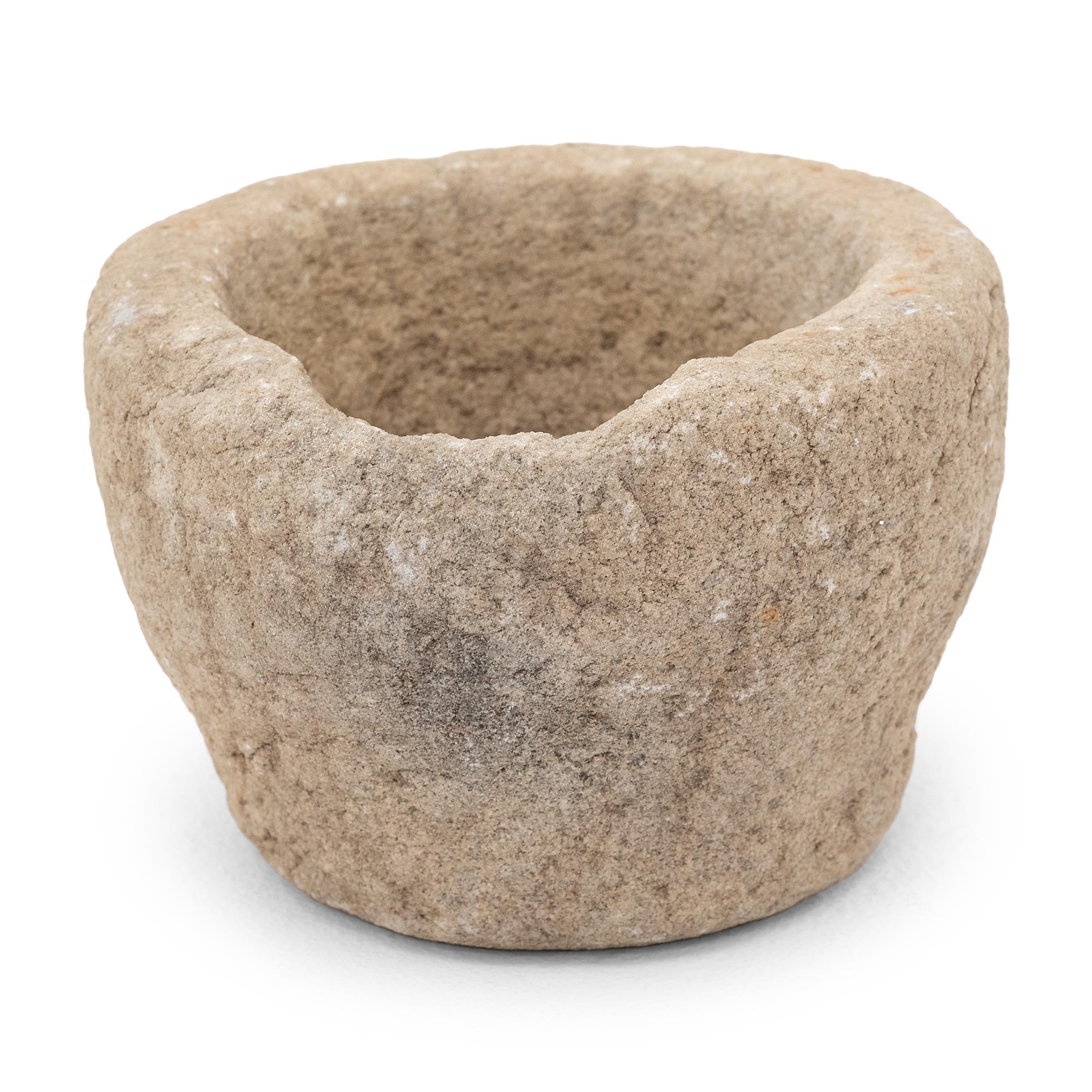 Carved from a single block of granite, this stone vessel is an early 19th century mortar once used to grind spices, herbs, and other condiments. The timeworn exterior is patterned with chisel marks, while the interior is smooth to the touch from