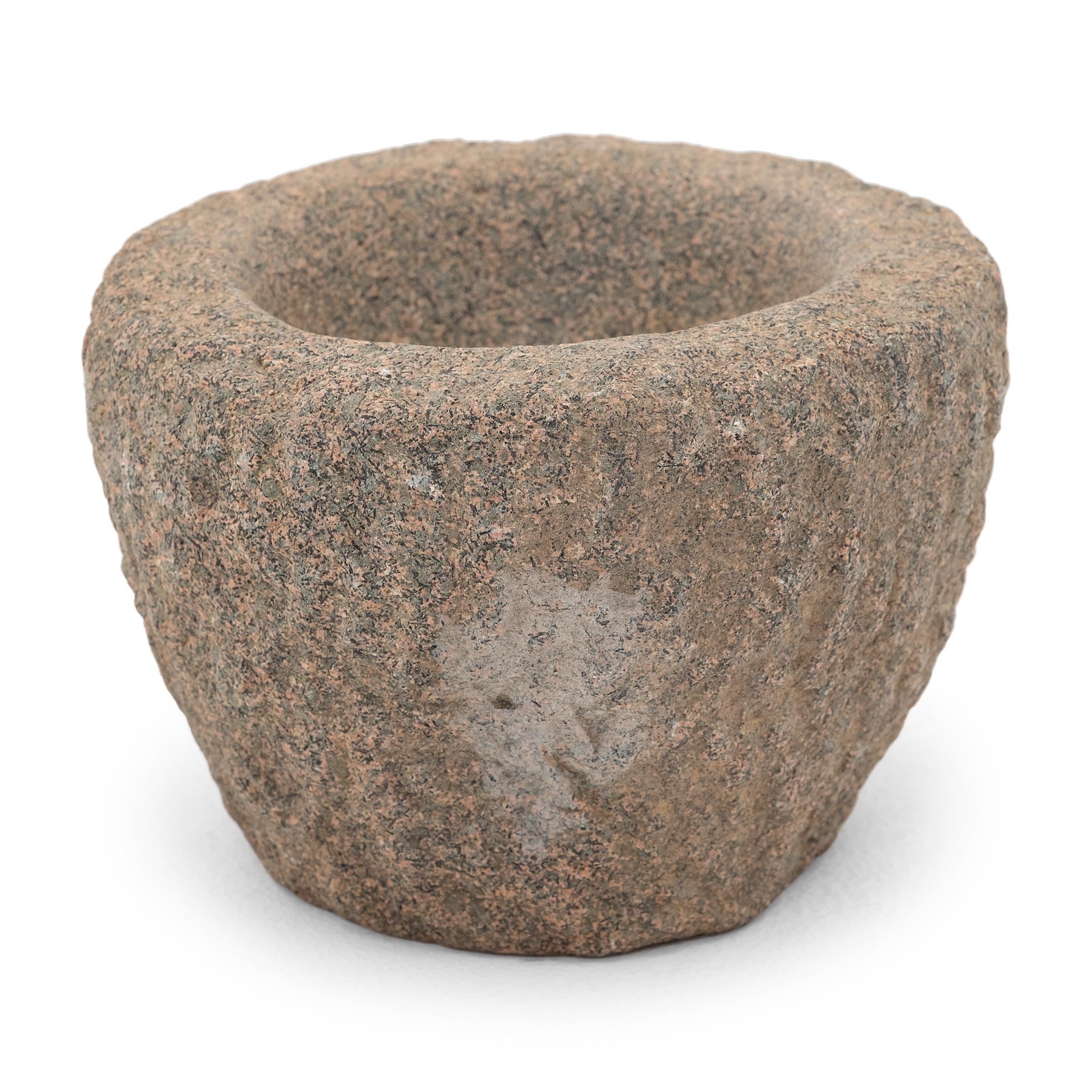 Ricavato da un unico blocco di granito, questo recipiente in pietra è un mortaio dell'inizio del XIX secolo utilizzato in una cucina cinese per macinare spezie, erbe e altri condimenti. I segni di scalpello caratterizzano l'esterno in pietra grezza,