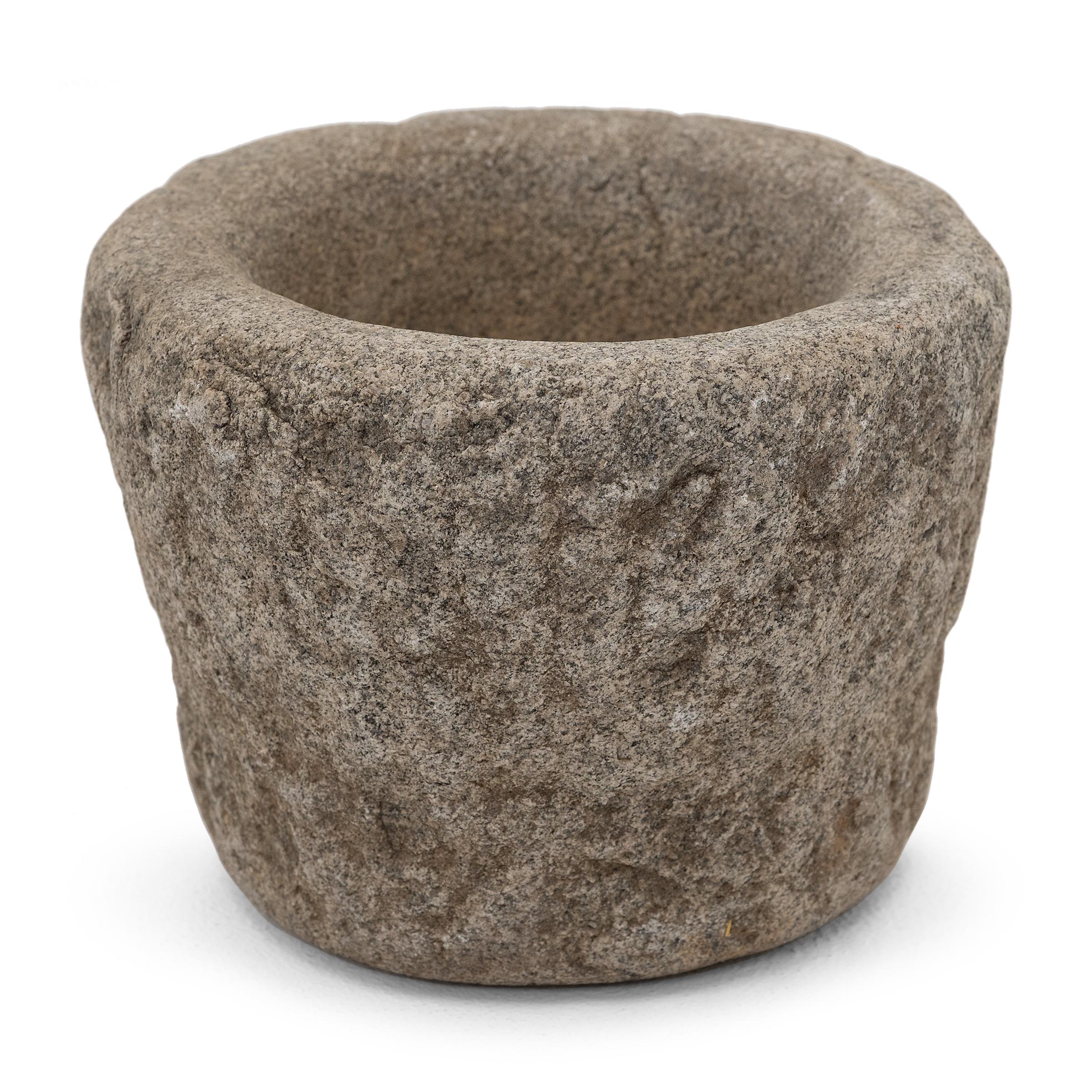 Ricavato da un unico blocco di granito, questo recipiente in pietra è un mortaio dell'inizio del XIX secolo utilizzato in una cucina cinese per macinare spezie, erbe e altri condimenti. I segni di scalpello caratterizzano l'esterno in pietra grezza,