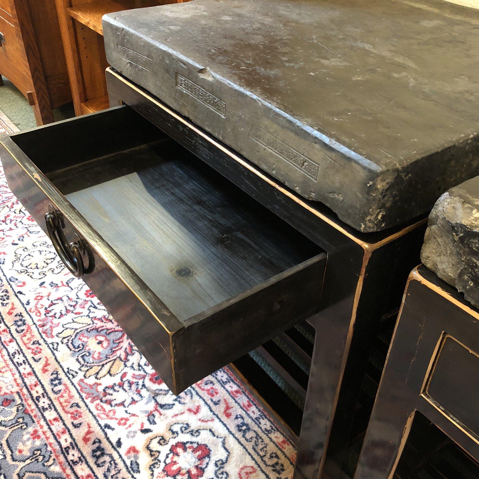 Two antique Chinese end tables with stone tops. Each piece features a slatted lower shelf, pull drawer, and bronze hardware. There is minor wear as may be expected with carved stones already rustic in nature.

Original price: $5,000.00.