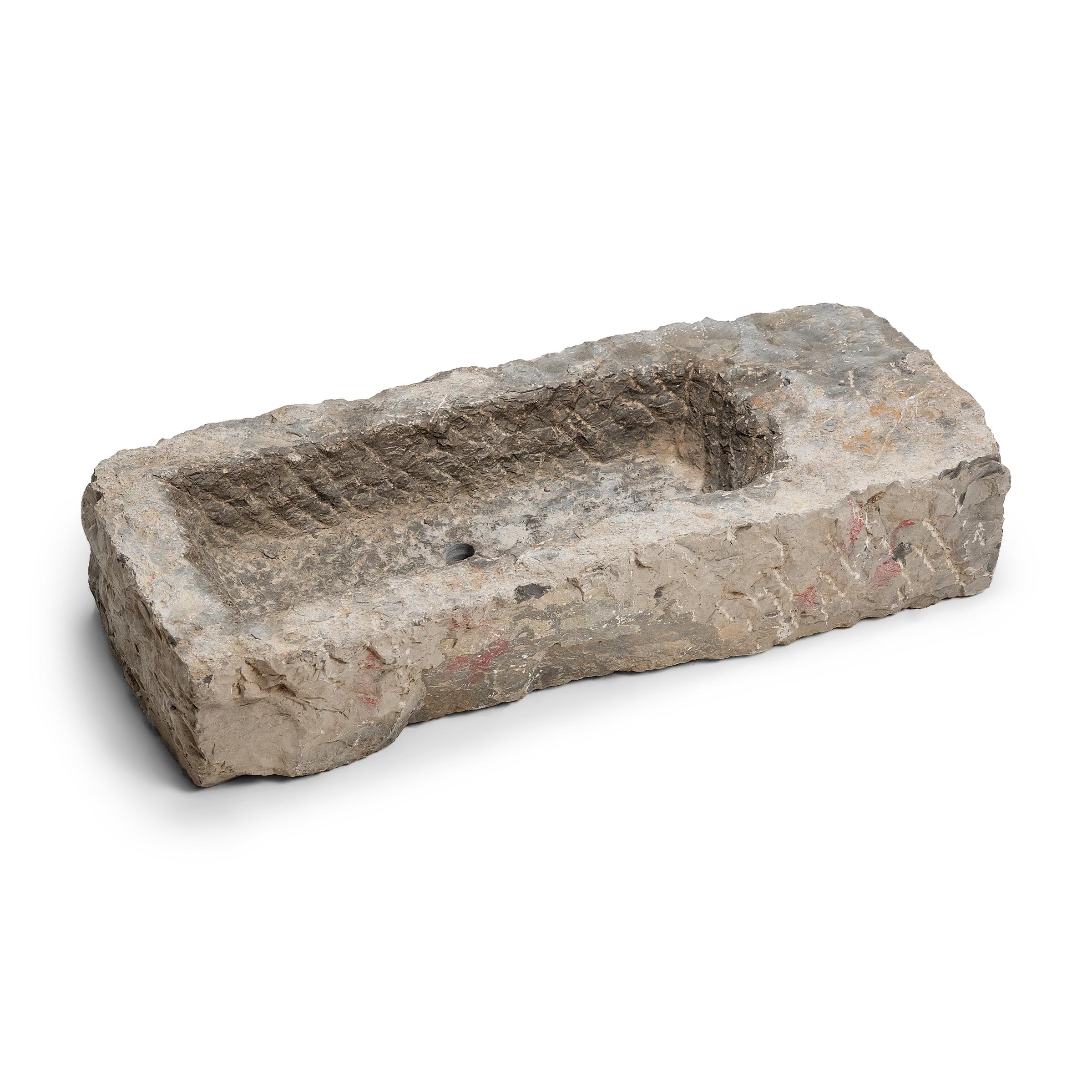 Once used on a provincial Chinese farm to hold water or animal feed, this early 19th-century stone trough is celebrated today for its organic form and rustic authenticity. Hand-carved from solid limestone, this rectangular trough has been carved