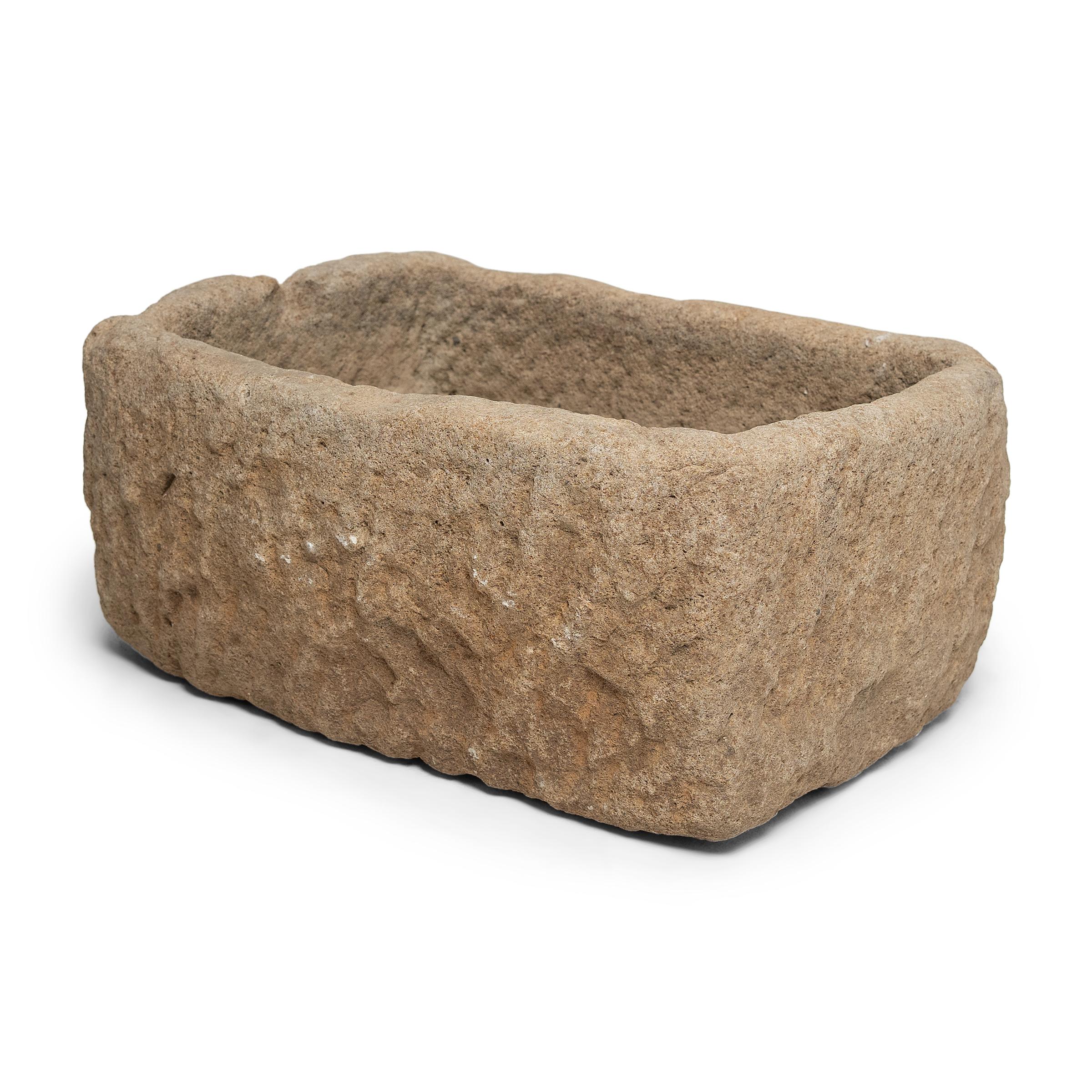 Once used on a provincial Chinese farm to hold water or animal feed, this early 20th century stone trough is celebrated today for its organic form and rustic authenticity. The trough is hand-carved from solid limestone with a rectangular form,