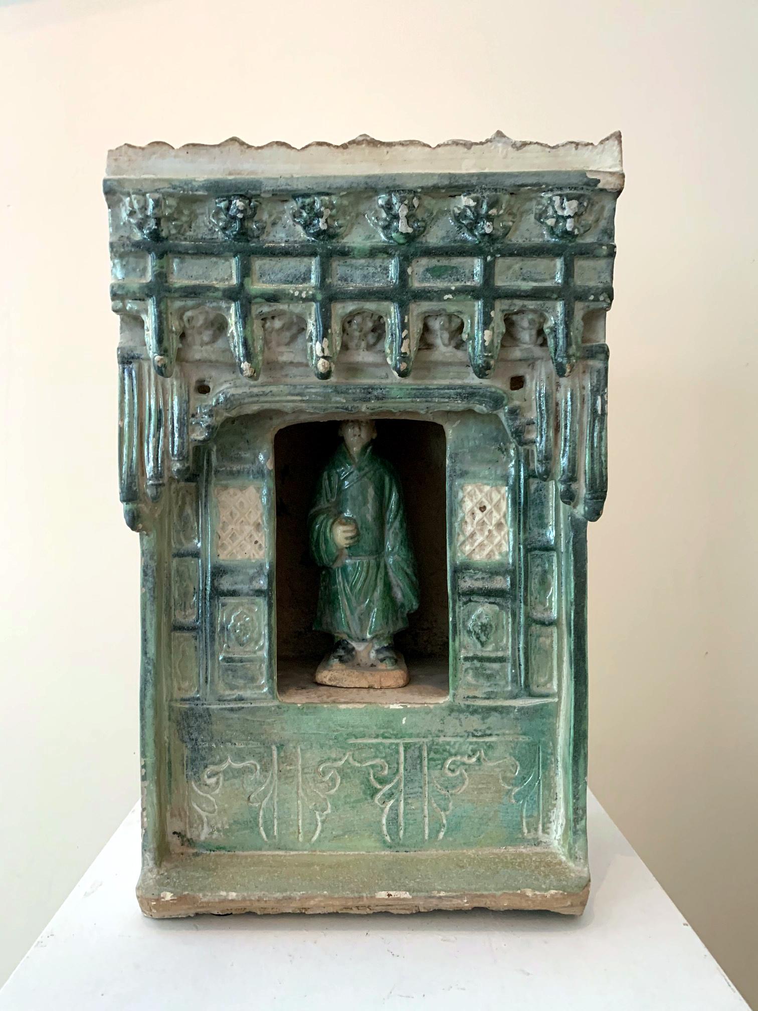 A stoneware shrine model with a figurine made in Ming dynasty (15th-17th century) in China and used as funeral burial objects. It is not known whether the two objects were originally associated, but they display similar glaze and oxidation and were