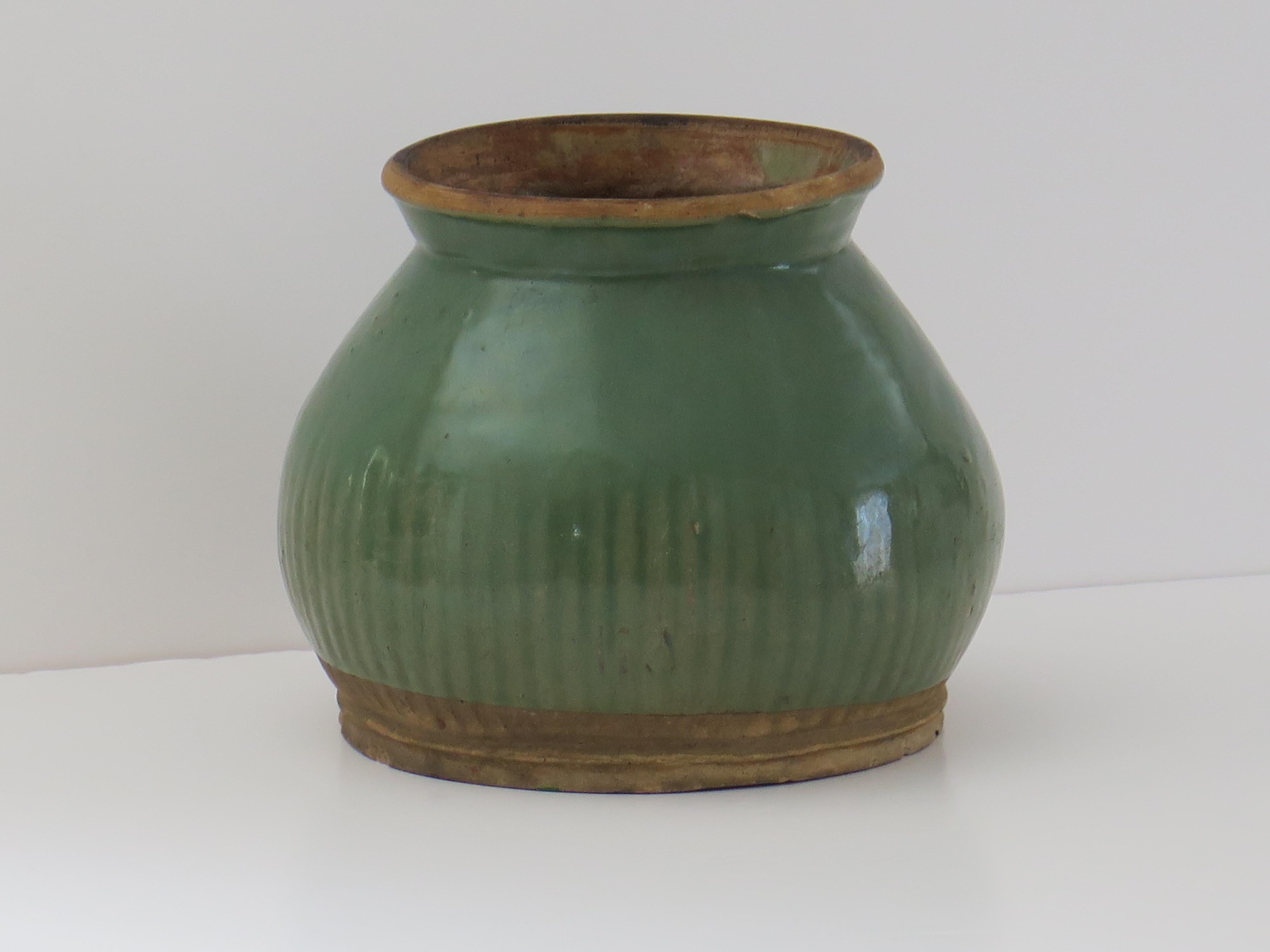 This is a very old interesting provincial Chinese stoneware Celadon Jar, probably Longquan,  with fluted or ribbed decoration, which we date to the Ming Dynasty, between the 14th and 16th Centuries.

The Jar has an interesting circular baluster