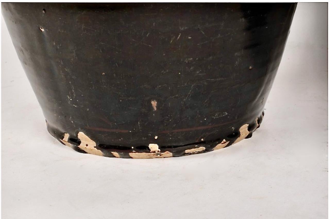 Ces impressionnantes jarres de stockage en grès chinois de la fin de la période Qing, à glaçure noire, trouveraient leur place dans un espace conçu dans le style d'Axel Vervoordt. Les deux jarres ont été coulées à la main avec une épaisse glaçure