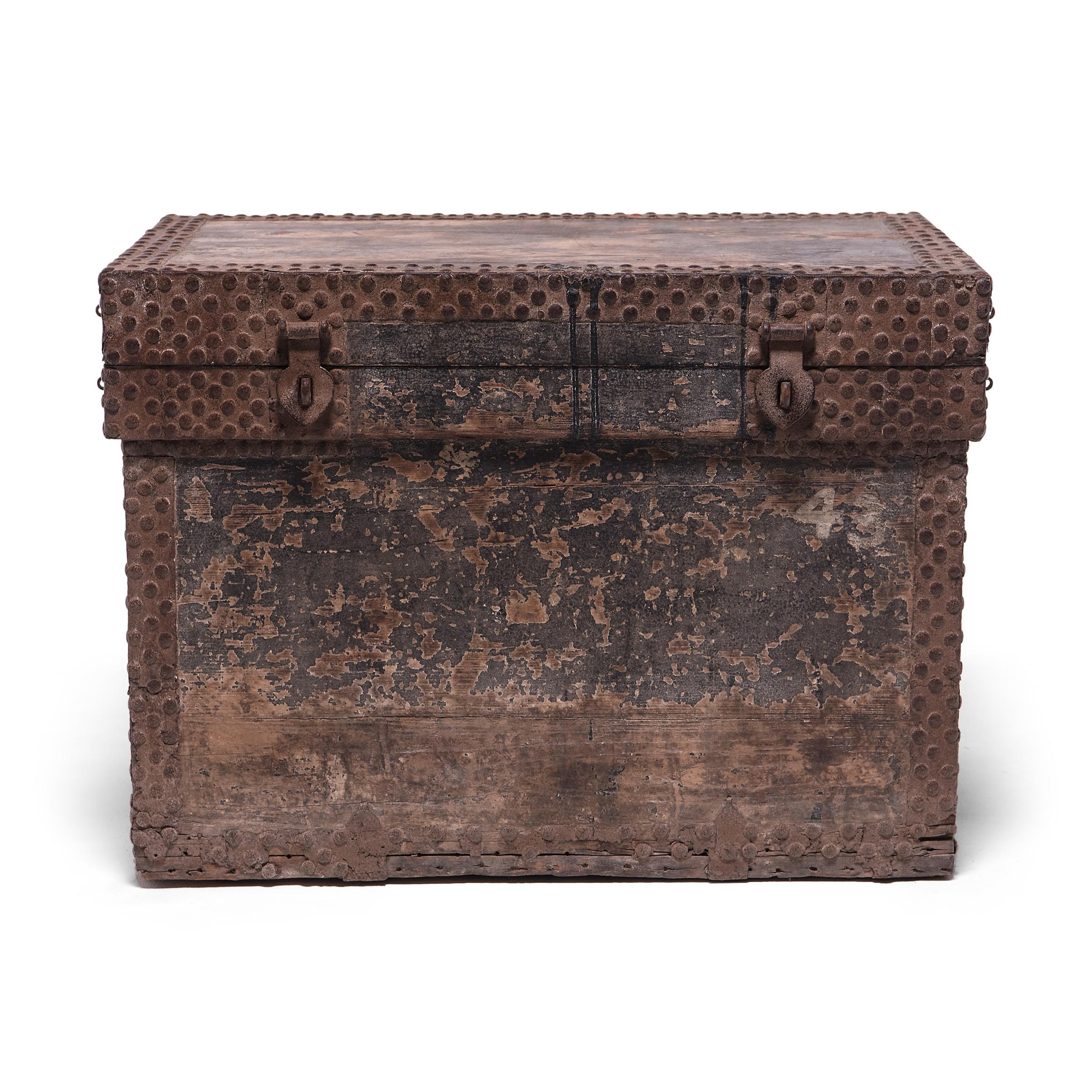 Studded with brass nails and textured by richly worn black lacquer, this spectacular trunk dates to the late Ming dynasty and would have been used by a wealthy family or merchant to transport money or precious goods. The subdued, neutral exterior