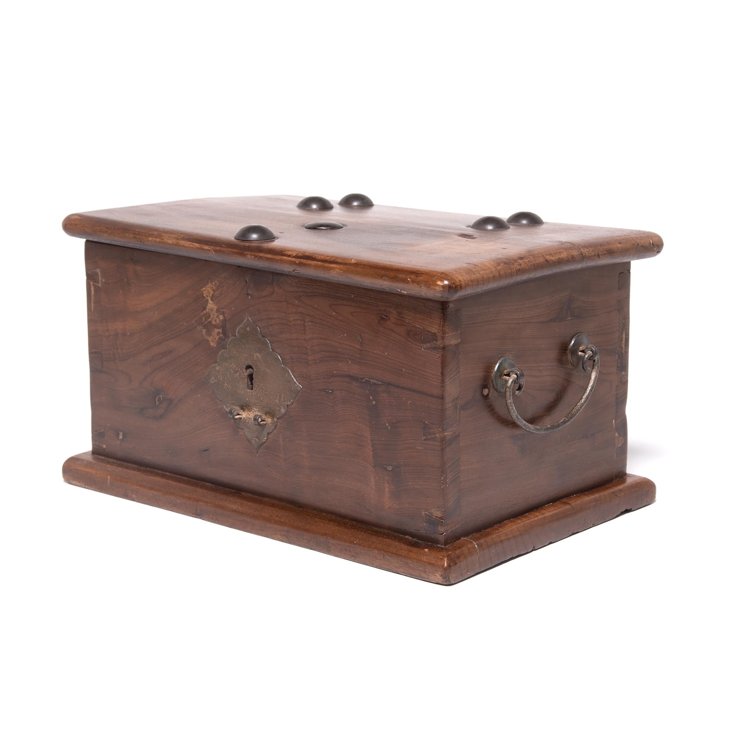 A special place for storing jewelry and other treasures, this early 19th-century lock box was created by a skilled artisan in China's Jiangsu province. The box is minimally decorated to showcase the rich, swirling grain of the nanmu wood, an